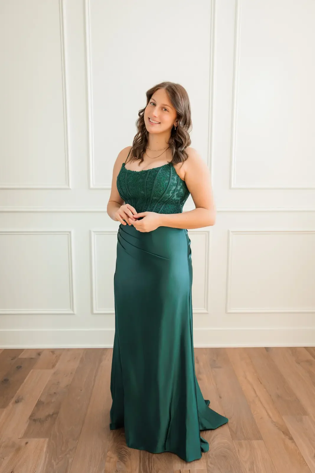 Senior girl wearing a long emerald green prom dress purchased from GLAM Prom in Clive, Iowa.