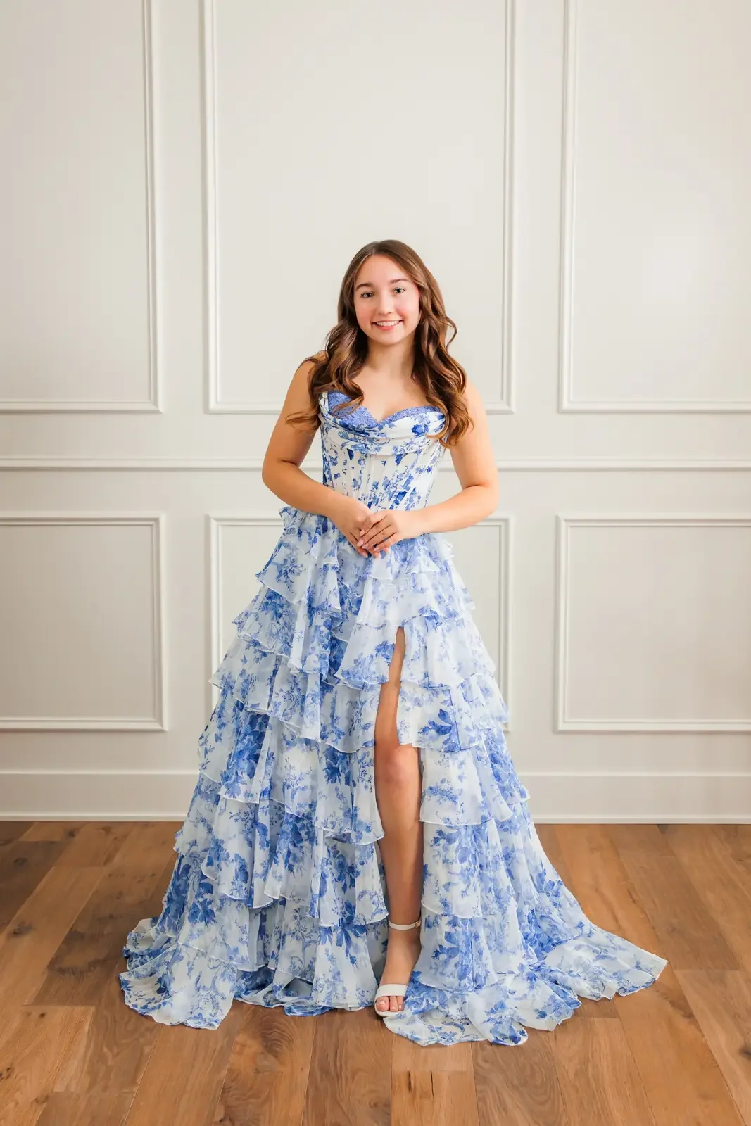 Senior girl wearing a Sherri Hill ruffled blue and white prom dress.
