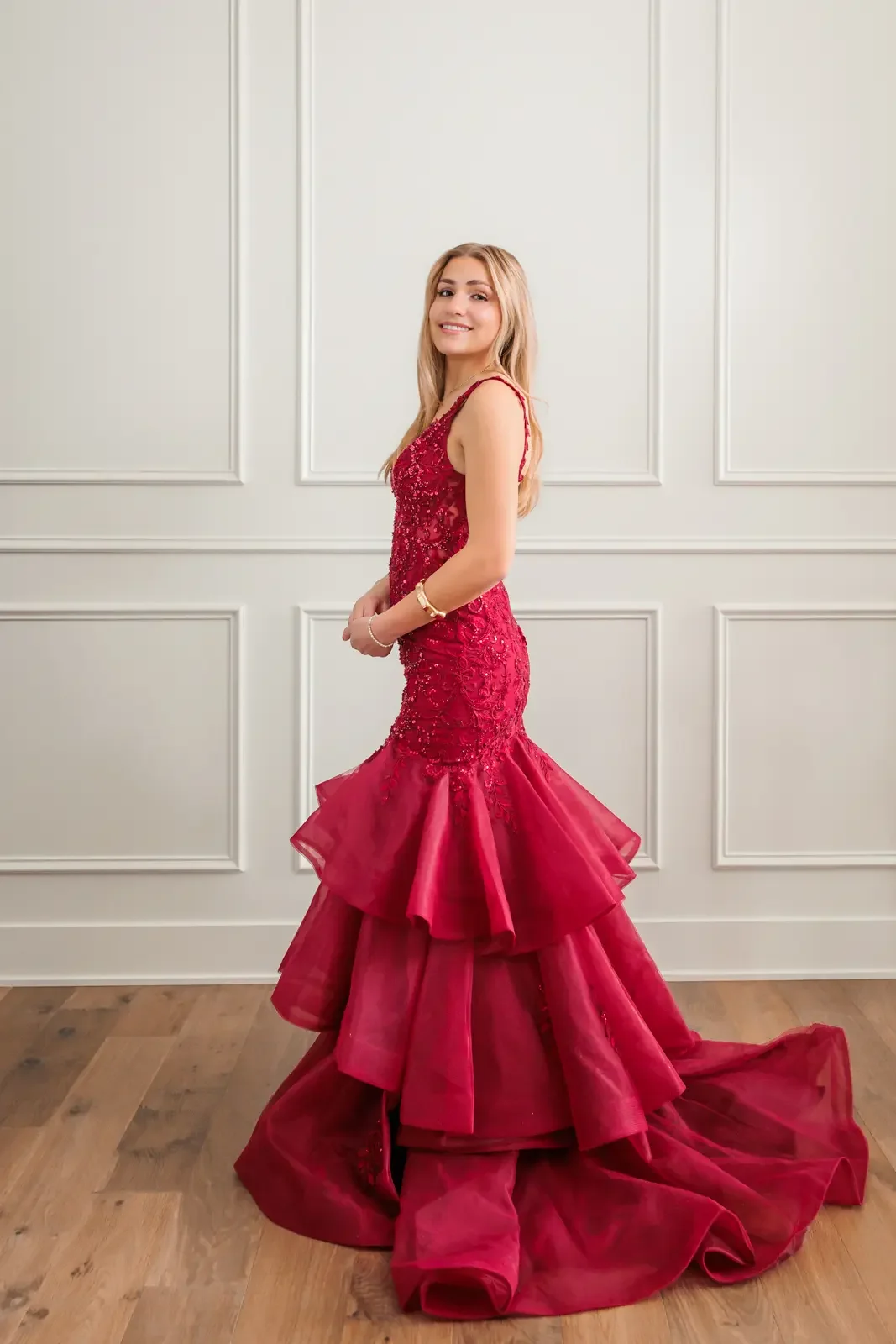 Senior girl wearing long mermaid style ruffled red prom gown.