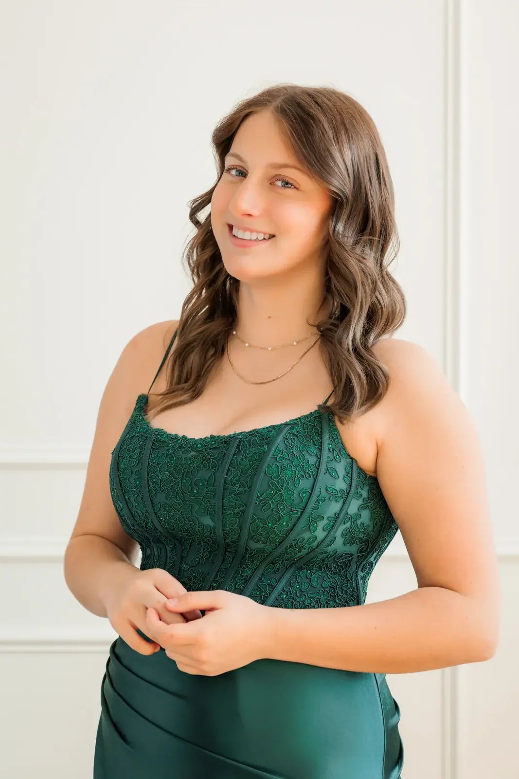 Close up of senior girl wearing an emerald green prom dress with lace detail on the bodice.