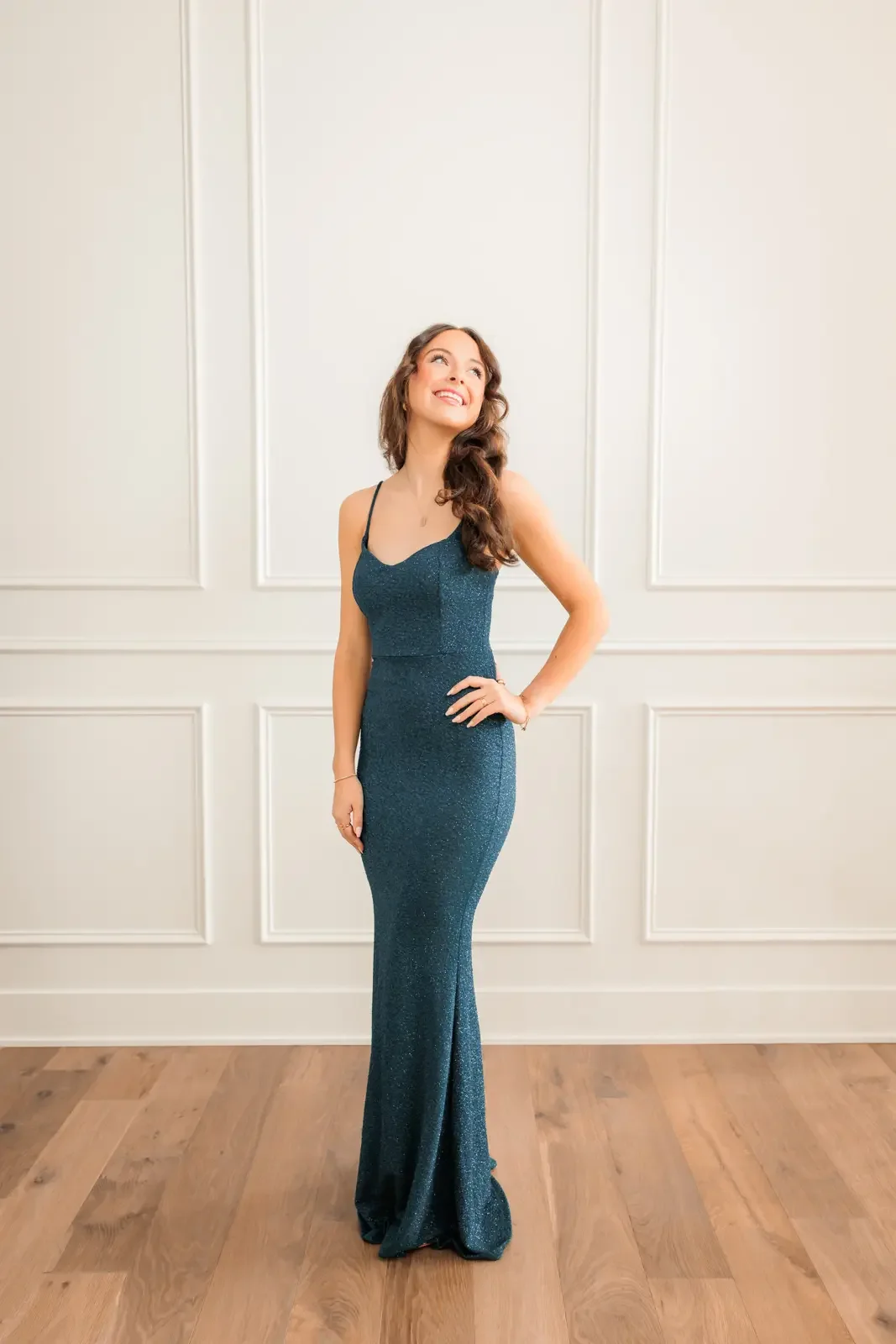 Senior girl wearing an elegant, fitted floor length prom dress.