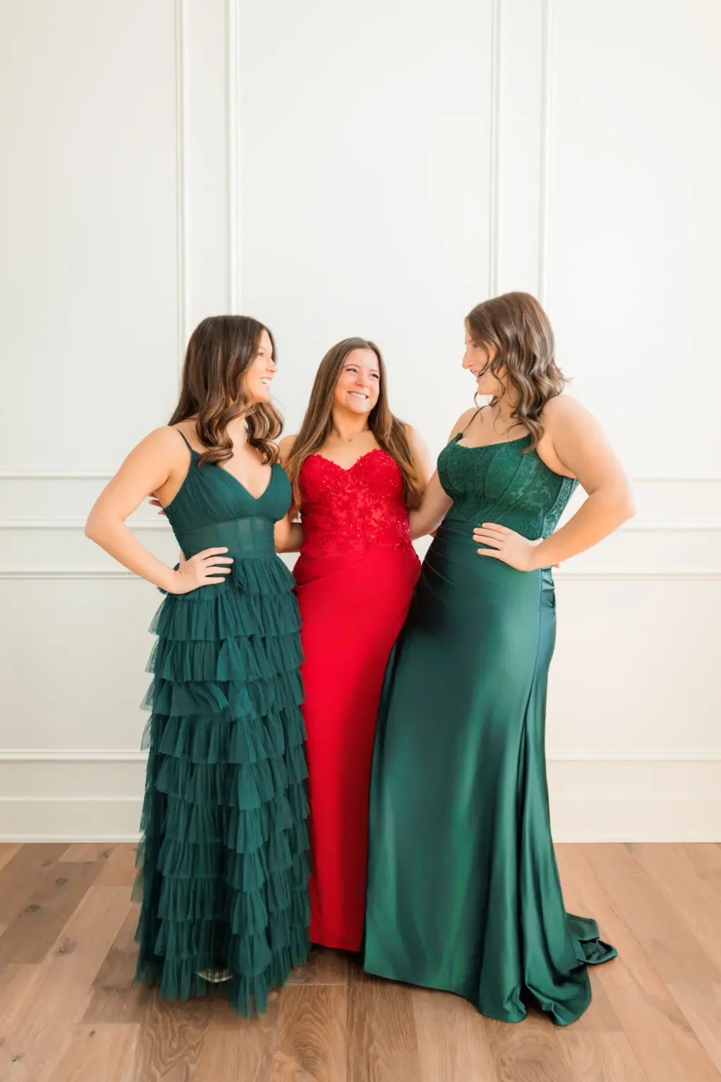 Three friends smiling and laughing together, modeling their prom dresses.  Photo by Wendy Sorensen, a Des Moines senior photographer.