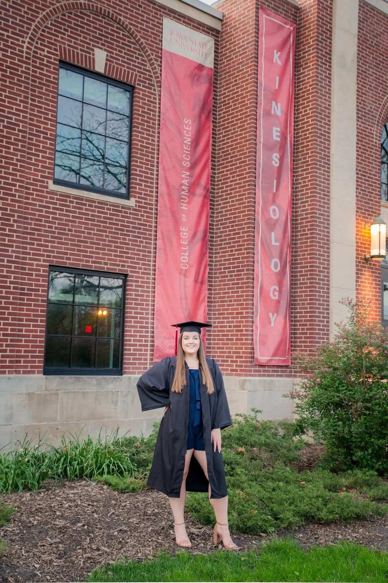 ISU grad with College of Human Sciences banner in the background.