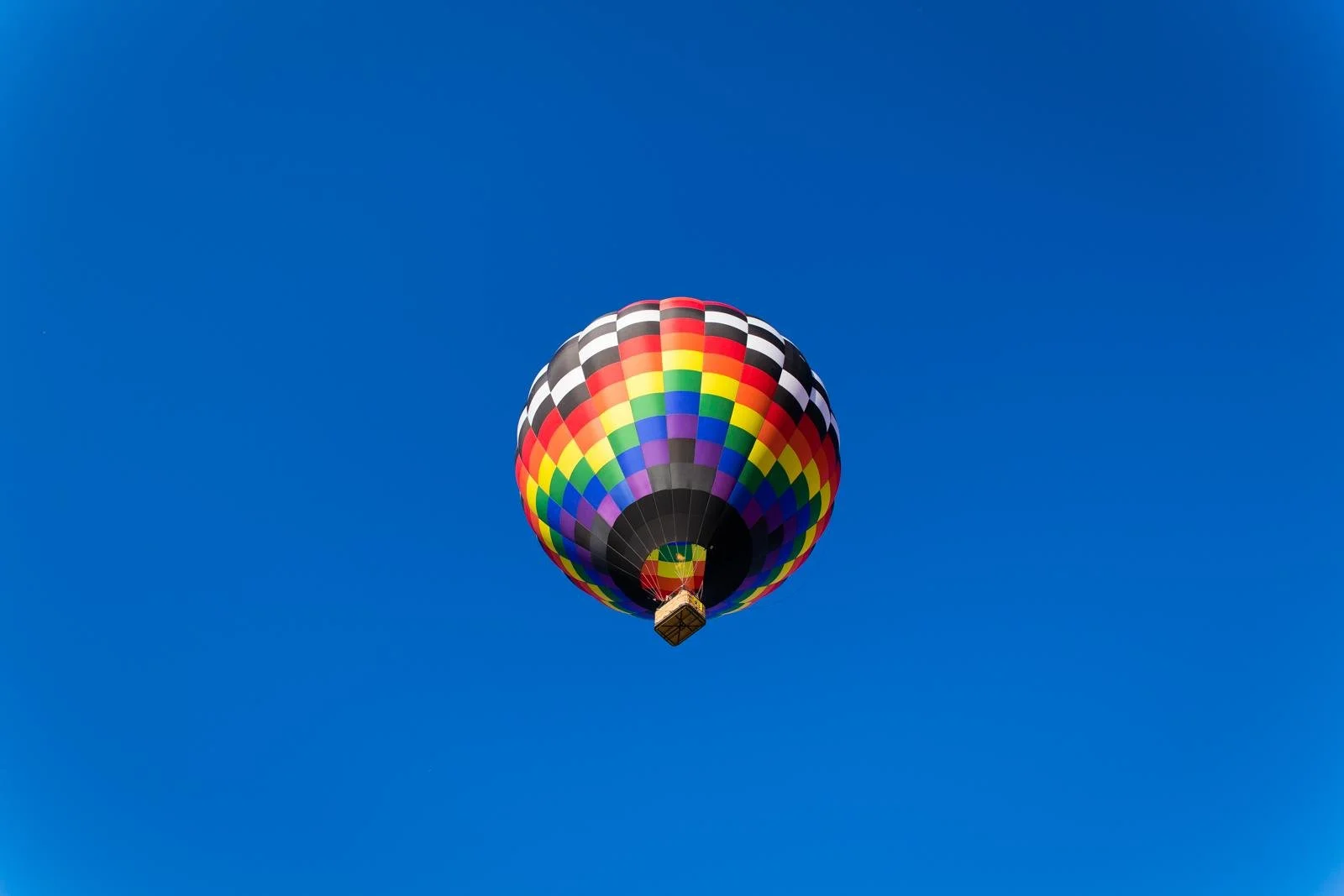 Colorful hot air balloon against a vibrant clear blue sky at the National Balloon Classic in Indianola, Iowa.