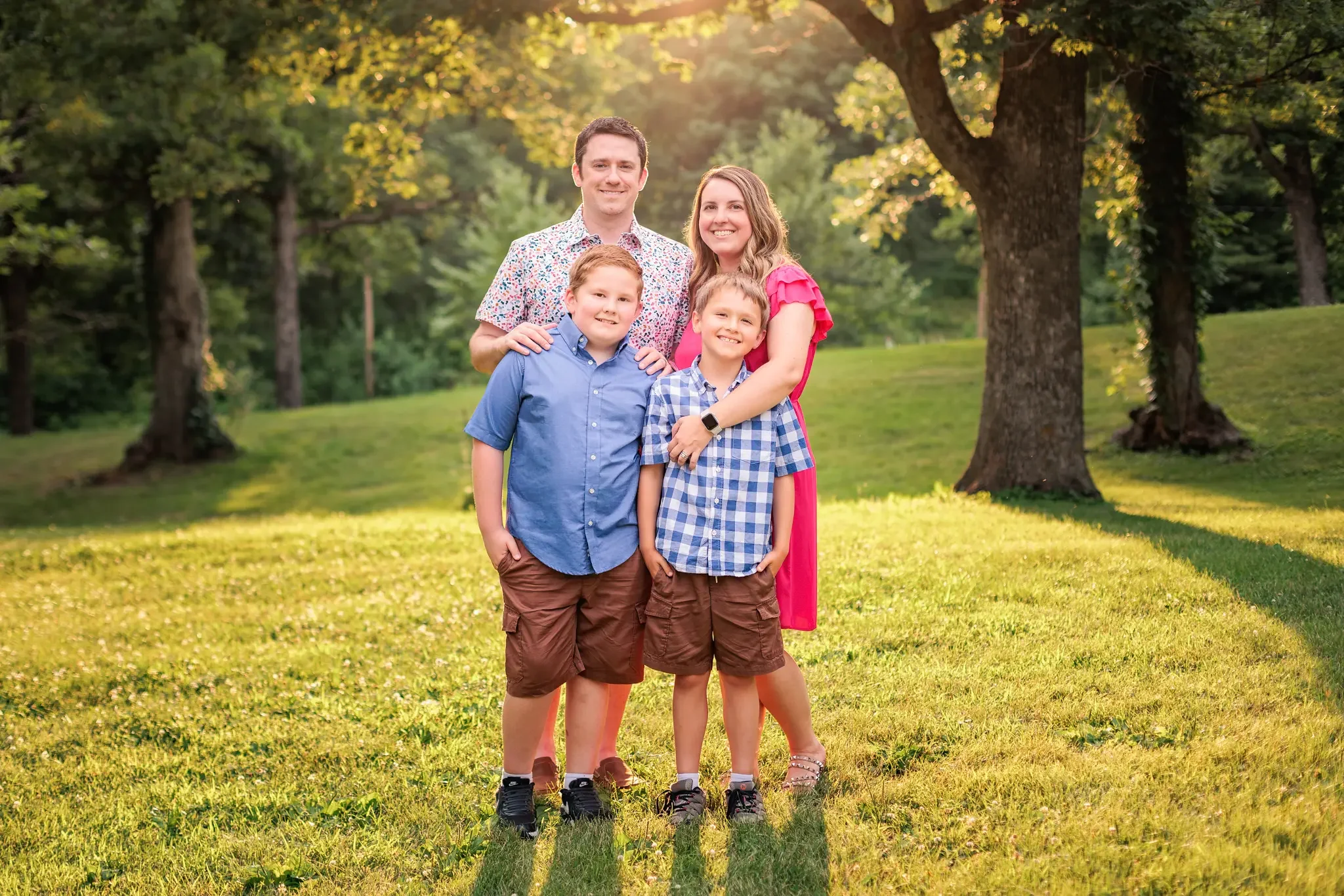 Family of 4 smiling at the camera during their family photo session in Des Moines, Iowa.