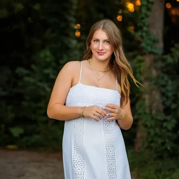 Senior girl with long hair wearing a white summer dress.