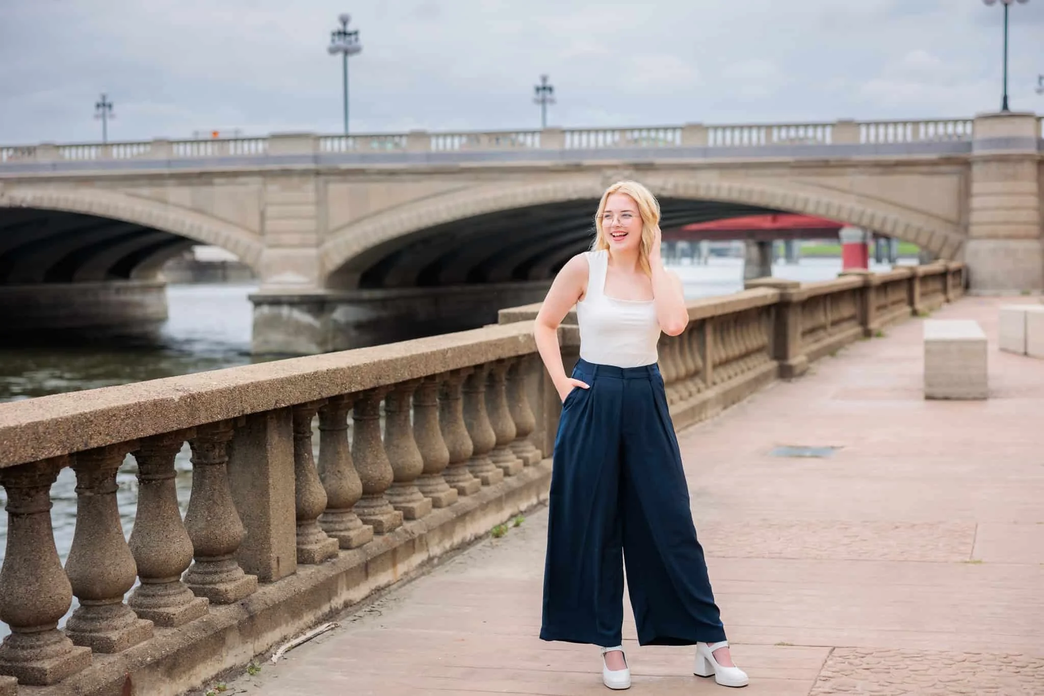 Senior girl standing along the Riverwalk in downtown Des Moines.