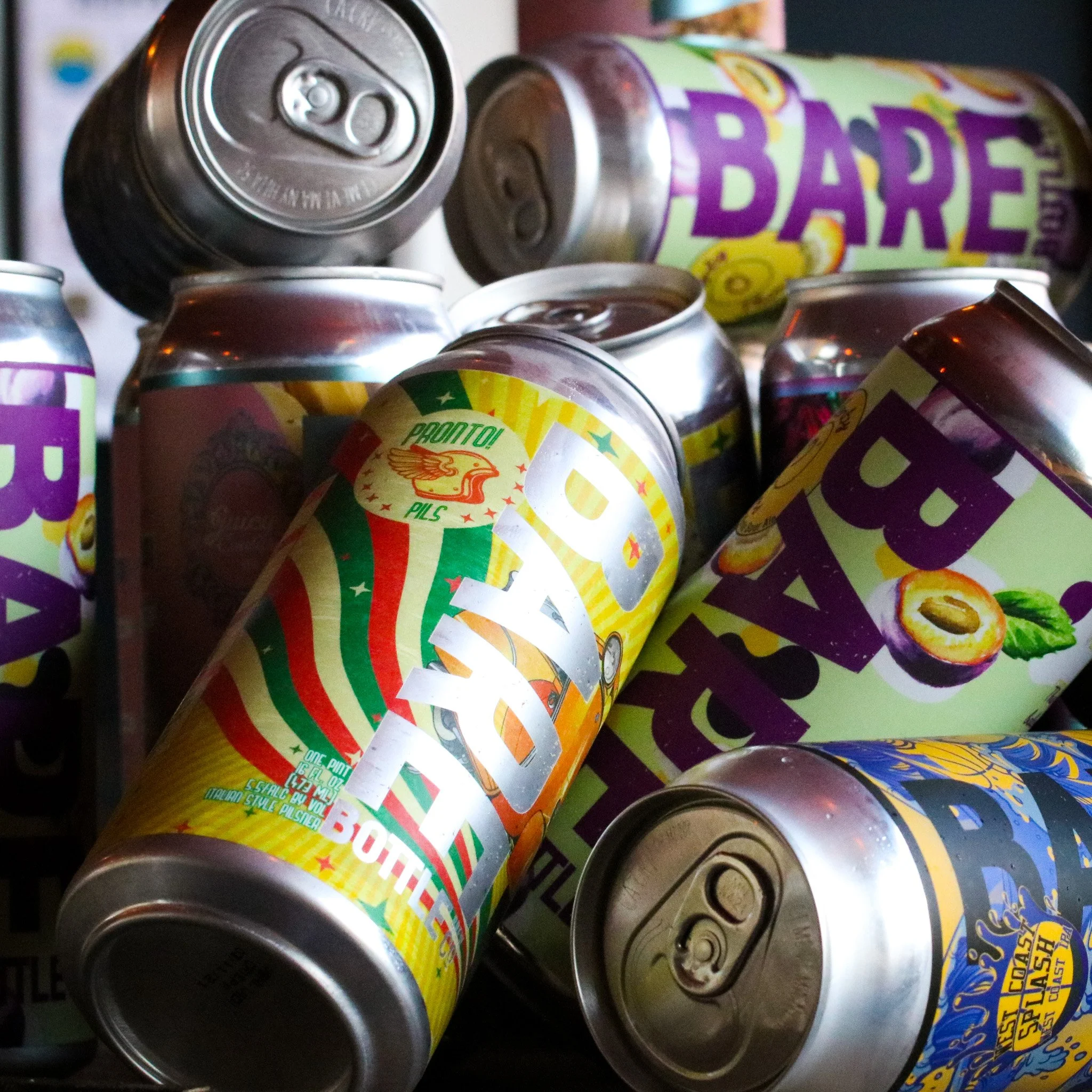 A pile of colorful soda cans with various labels and designs.