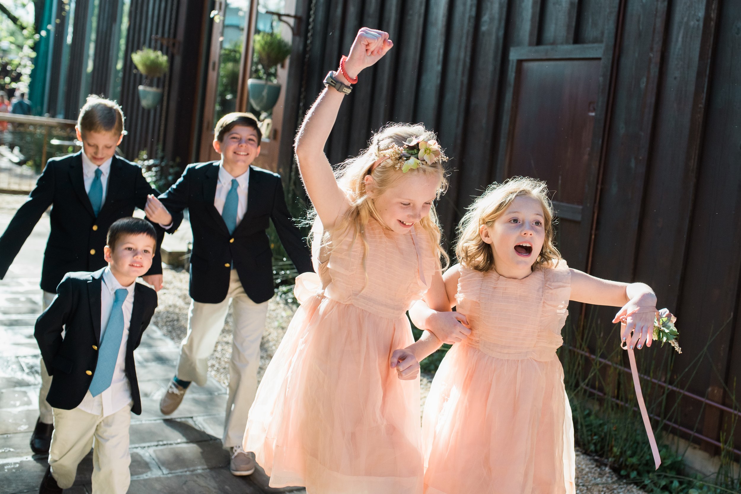 Flower girls with flower crowns dressed in soft pink romantic dresses recess from the wedding at Barndiva follows by the ring bearers in blazers.