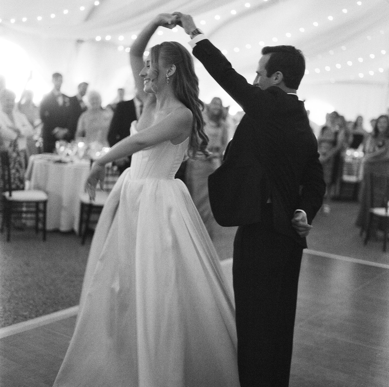 Black and white film photography of a bride and groom dancing at a tented wedding in Misselwood in coastal Massachusetts.
