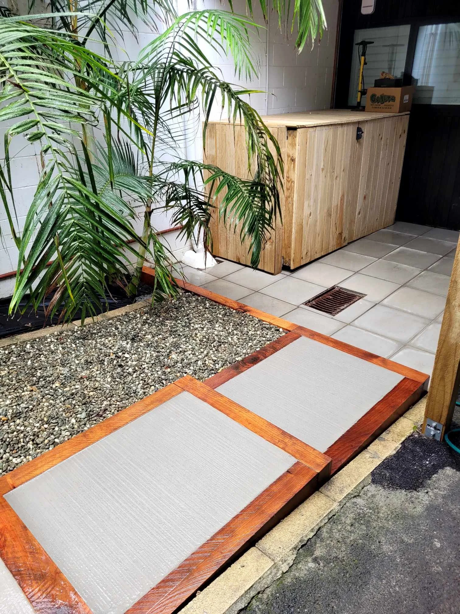 Macrocapra framed steps with paved patio and wooden storage box