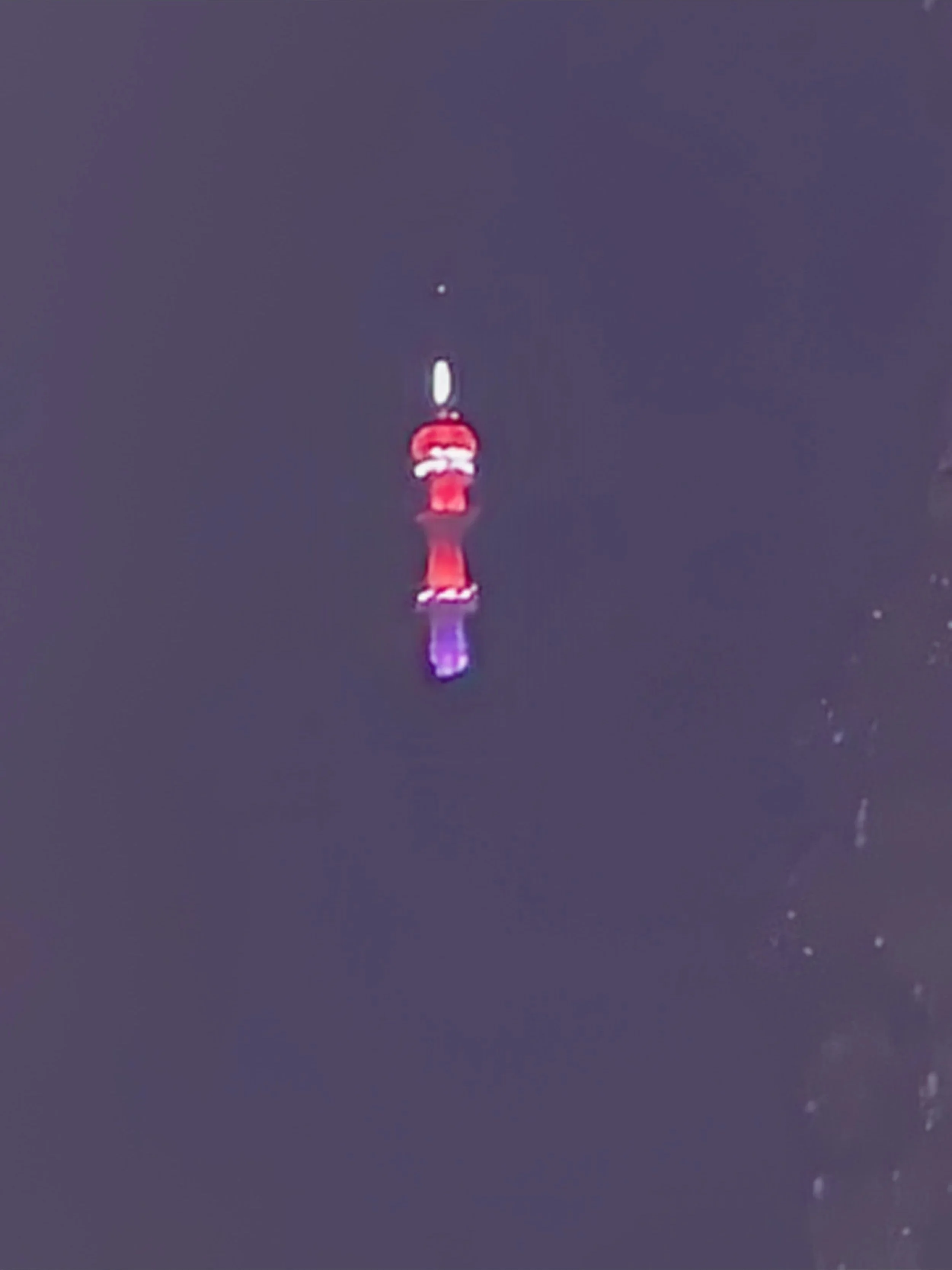 Nearby Turyapada Telecomms Tower is illuminated at night