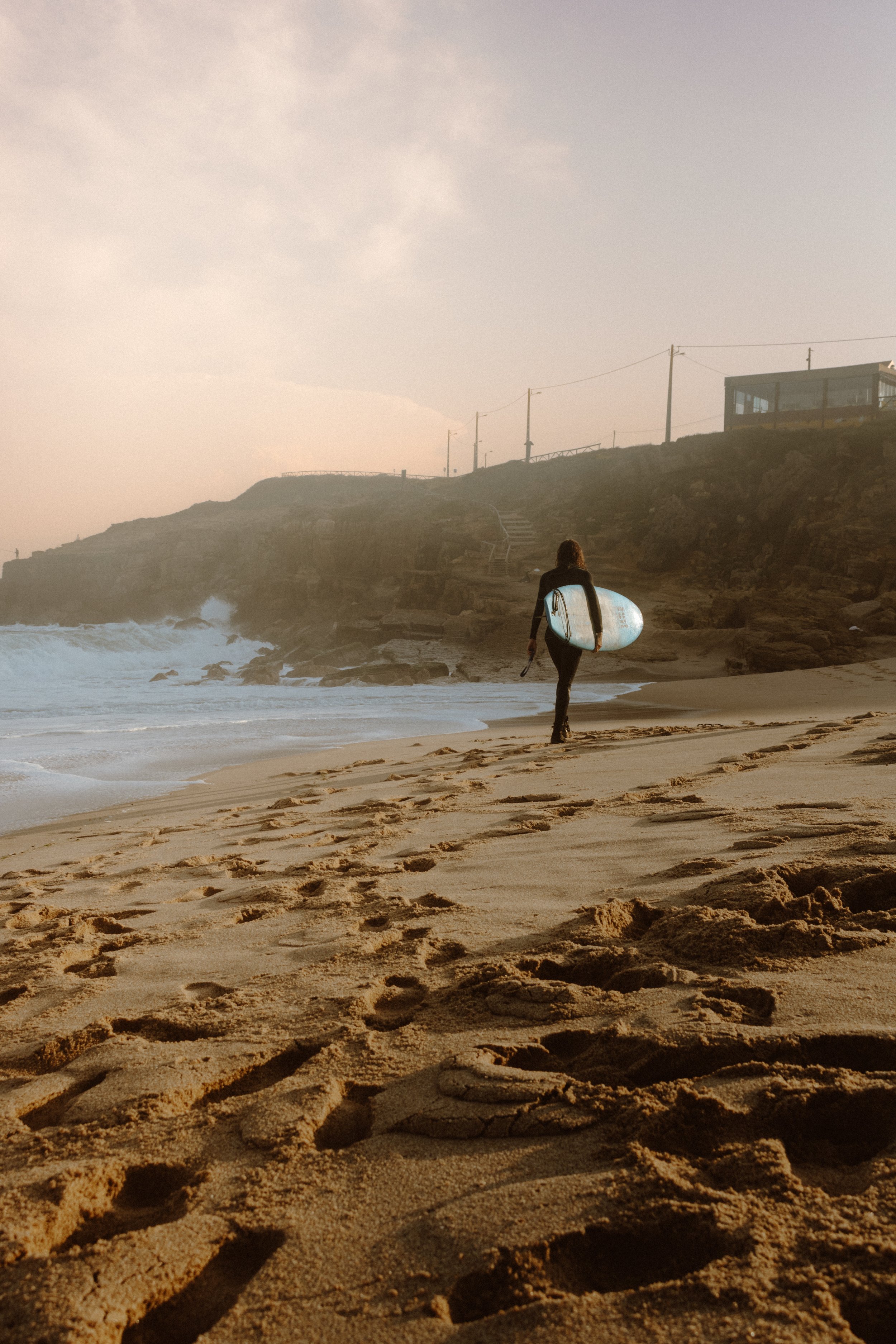 Surfer walking with his board on the beach