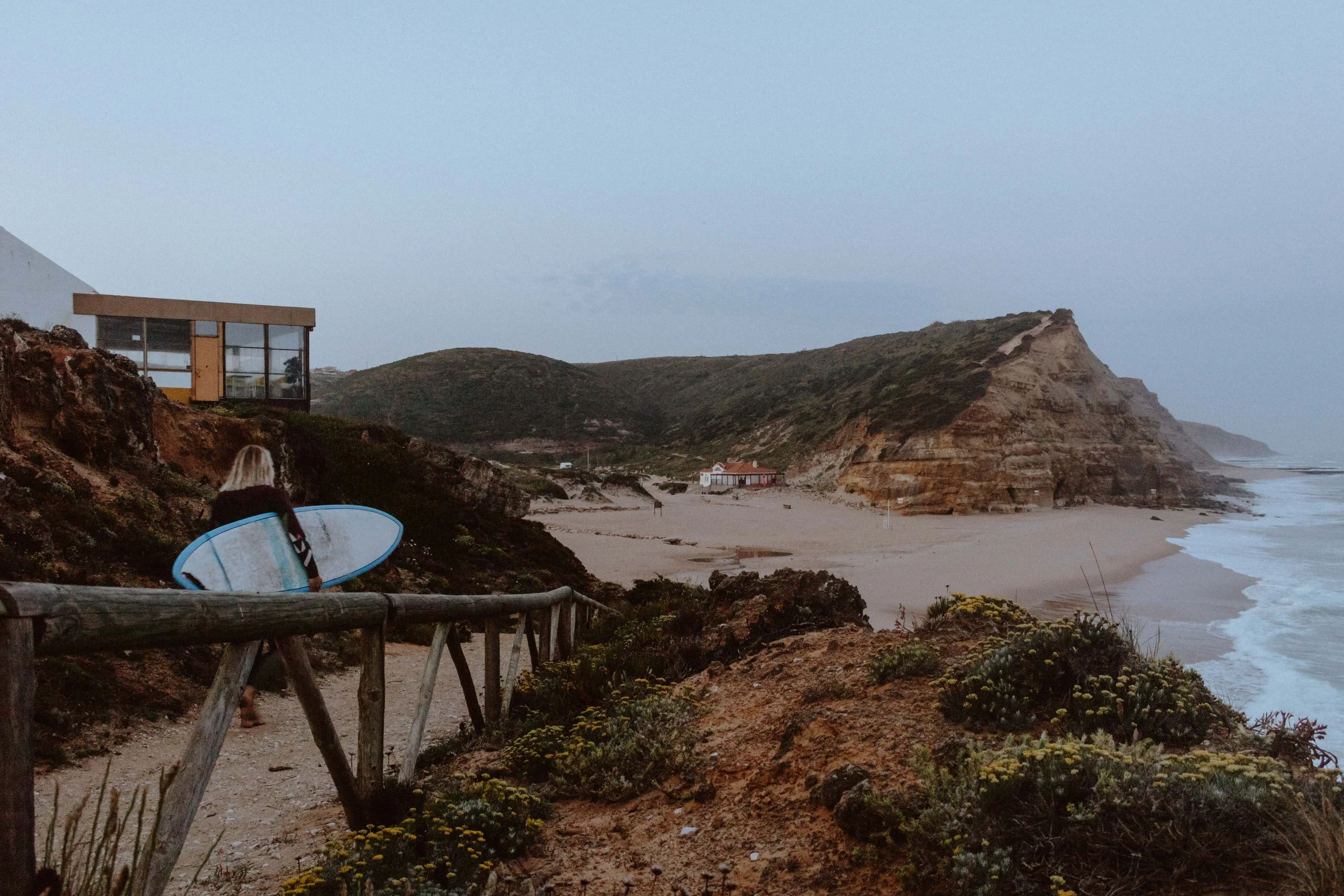 Surfer woman going down to the beach