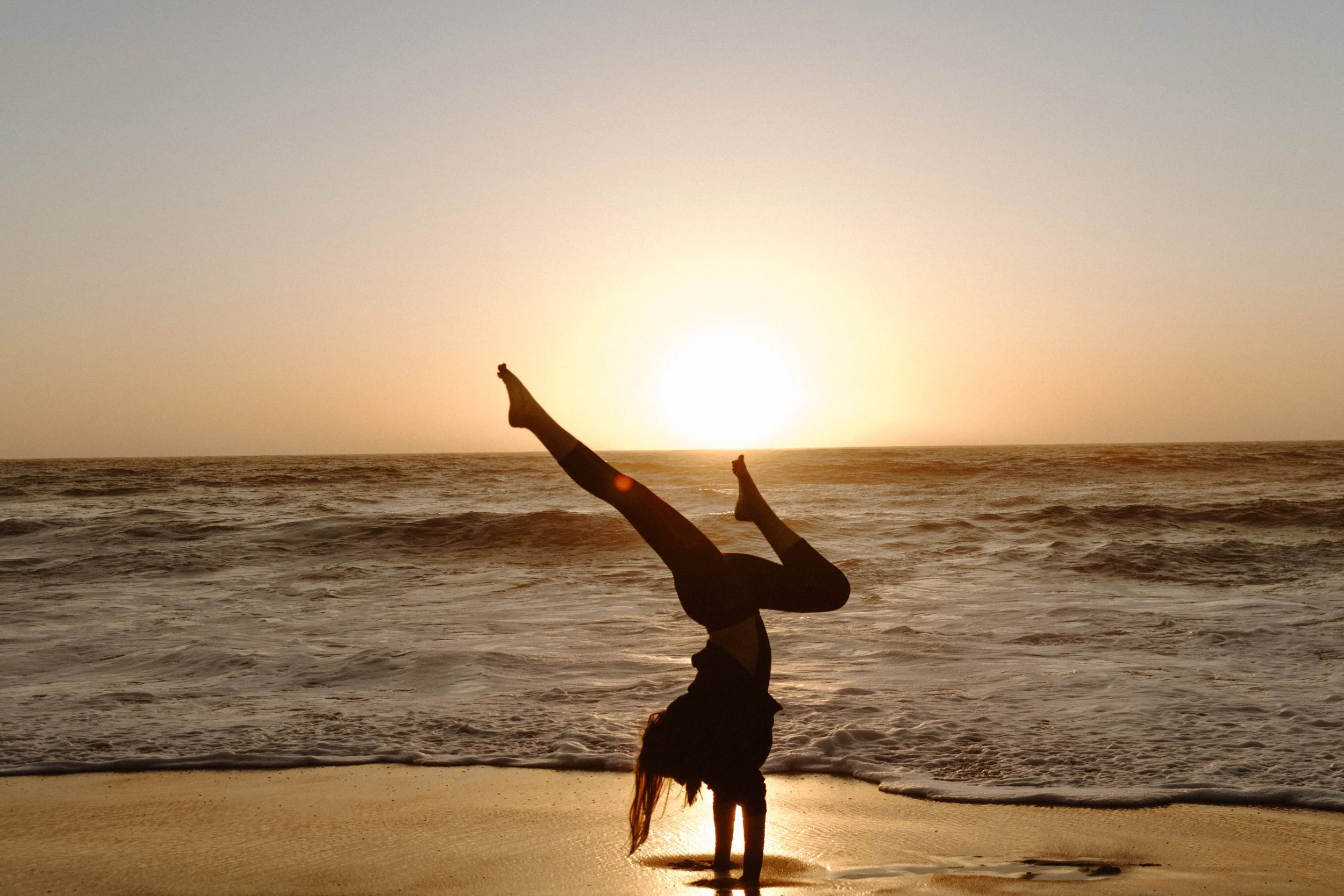 Athlete doing a handstand on the beach in portugal