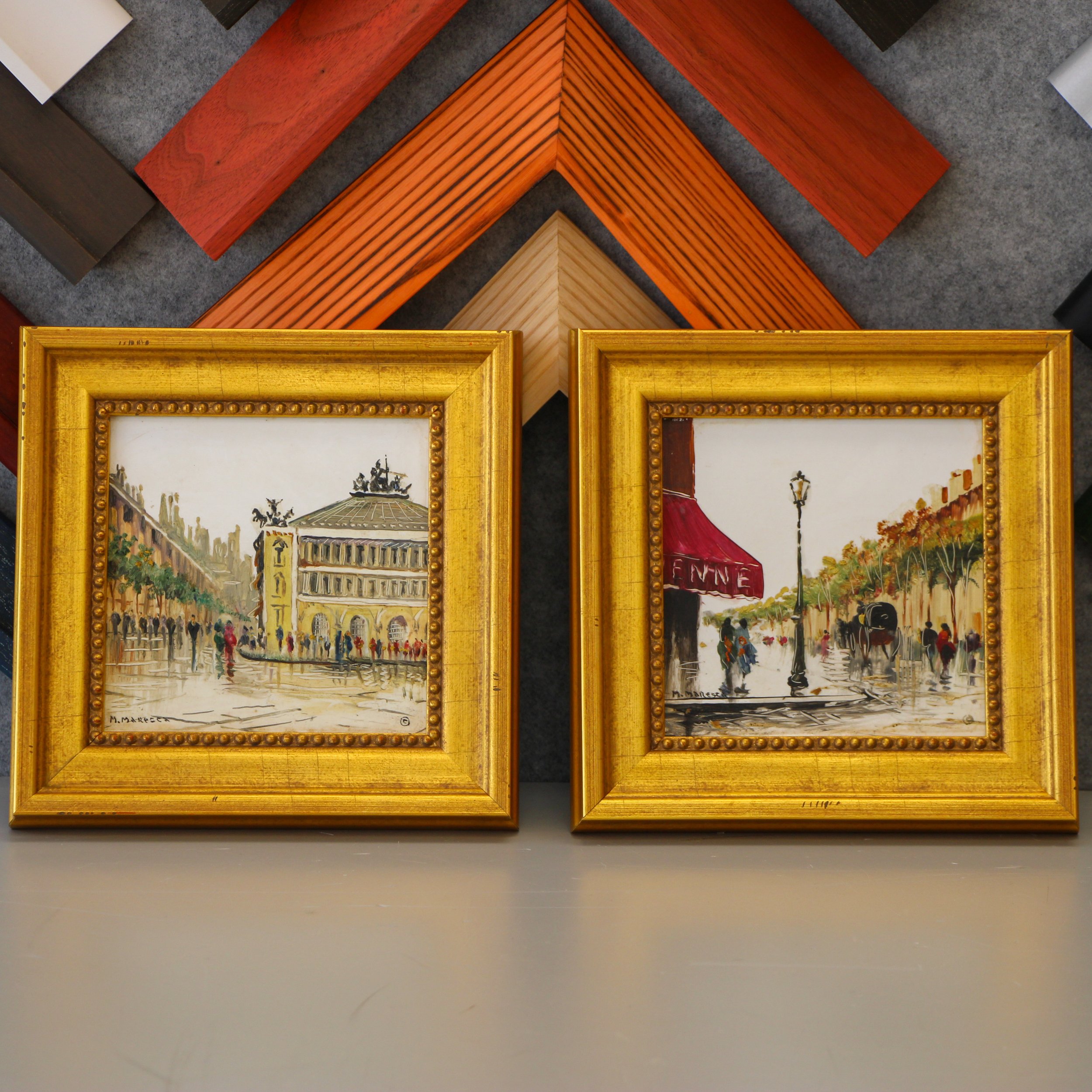 Two tiles with painted scenes of Paris in gold frames.