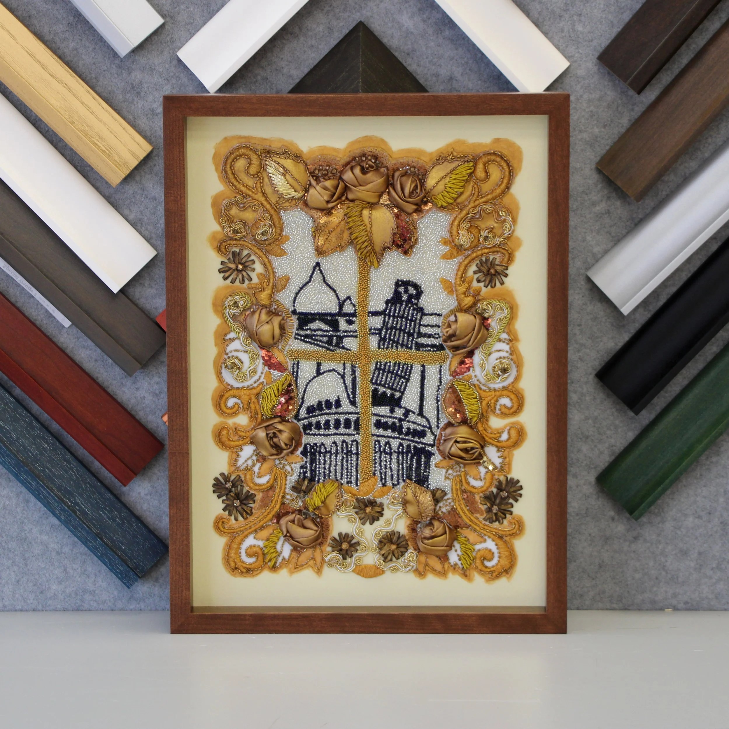 A textured and beaded embroidery in an understated brown frame.