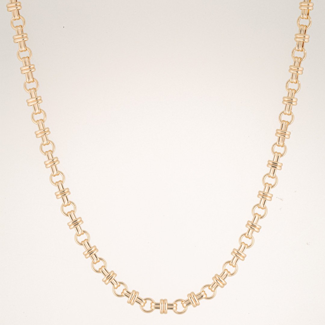 Original studio photograph showing the gold necklace suspended in a U-shaped arrangement against the curved white background