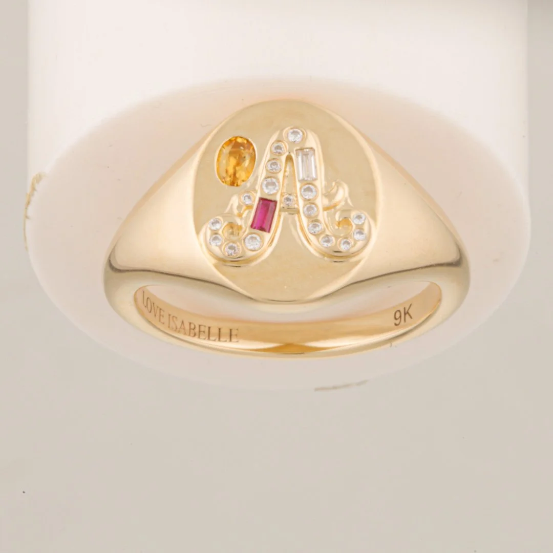 Original studio photograph showing the gold signet-style ring positioned upside down on the white support