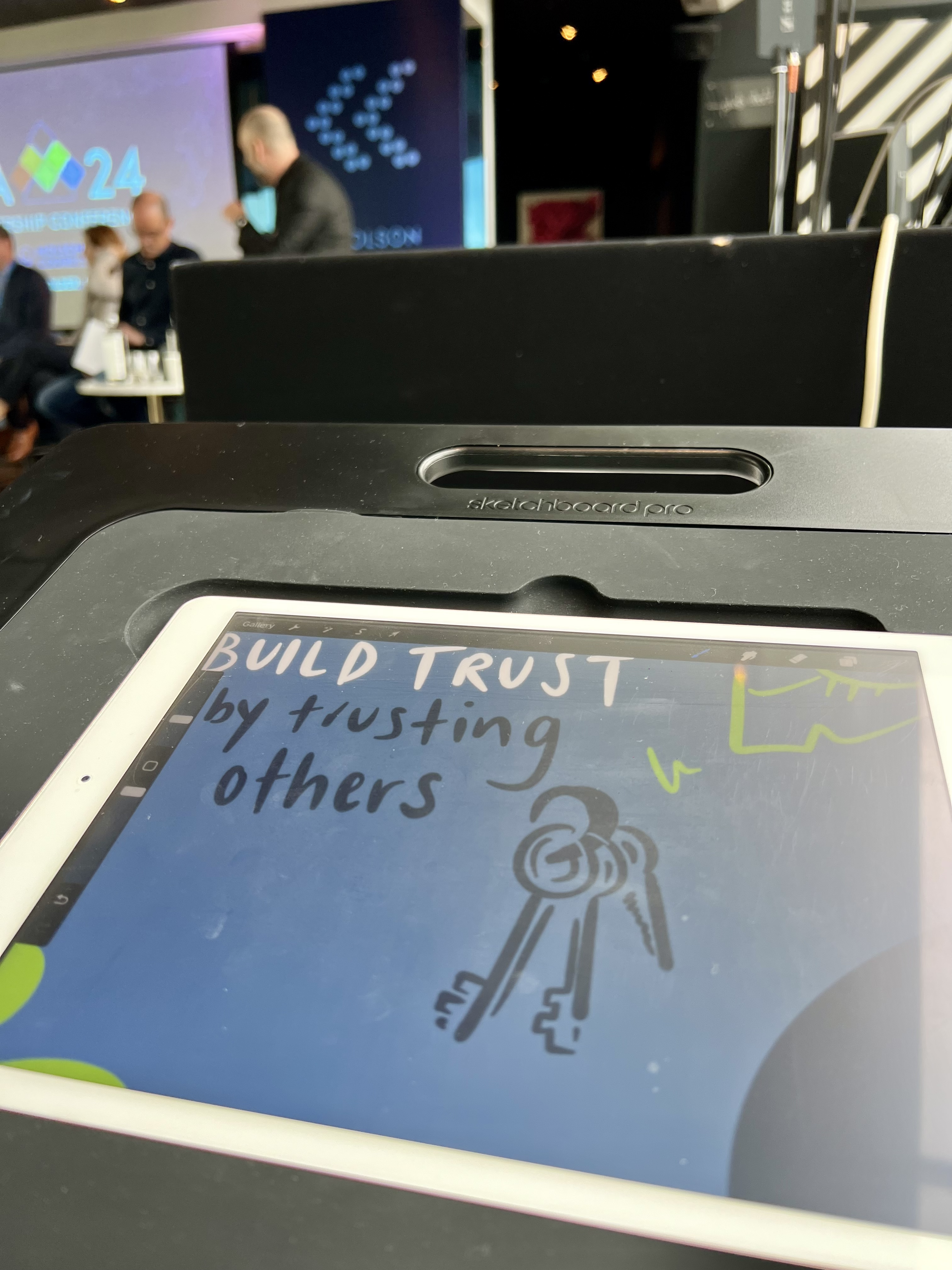 A close up of Esther's iPad where she was live illustrating at an event. The screen shows a drawing with the words "Build trust by trusting others".