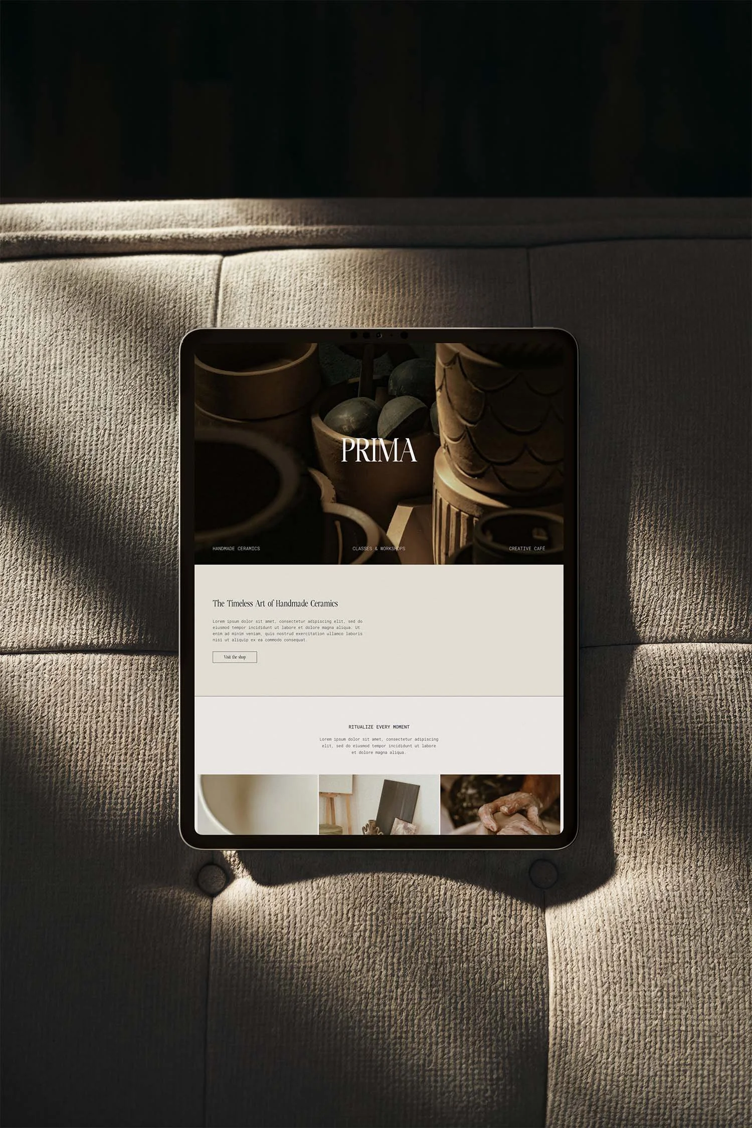 Tablet displaying a website on handmade ceramics resting on a textured fabric surface with sunlight glittering across.