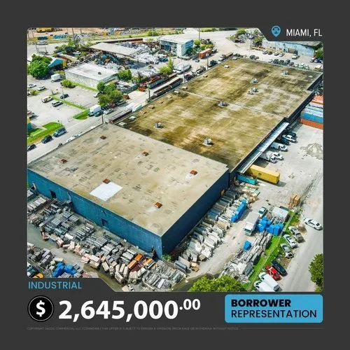 Aerial view of industrial property for sale in Miami, FL, priced at $2,645,000. The large warehouse facility is surrounded by various industrial materials and equipment.