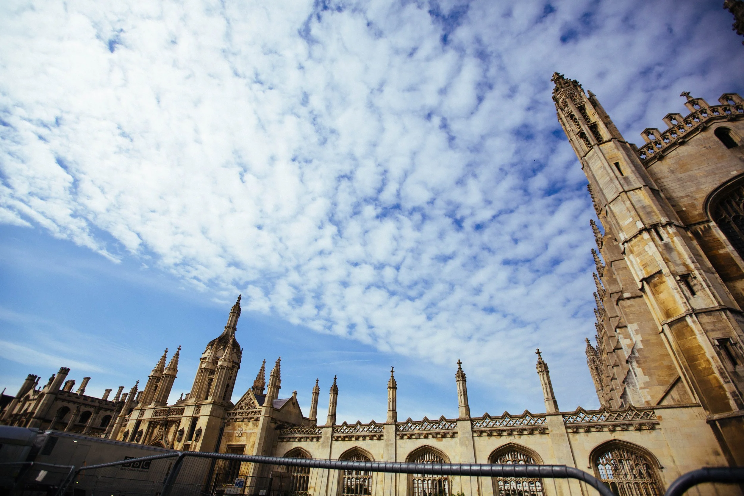 View of a historic Gothic cathedral with tall spires and ornate architecture under a partly cloudy sky