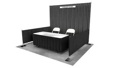 Exhibit booth with black fabric walls, a table, two chairs, and a small sign labeled 'Company Name' at the top
