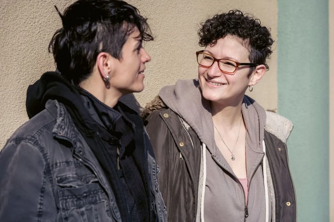 happy-lesbian-couple-having-conversation-on-sunny-autumn-street