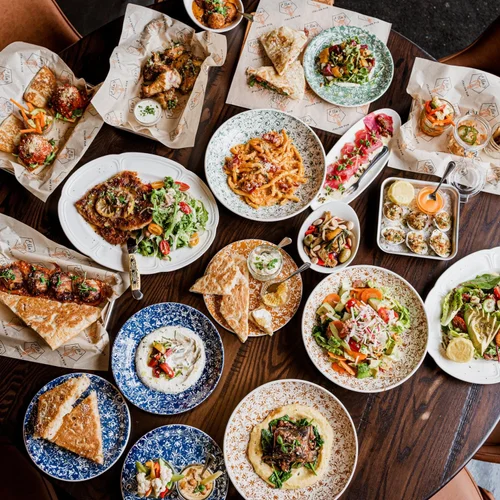 A table of Italian favorites, pasta, salads, and shareable dishes at Ella’s