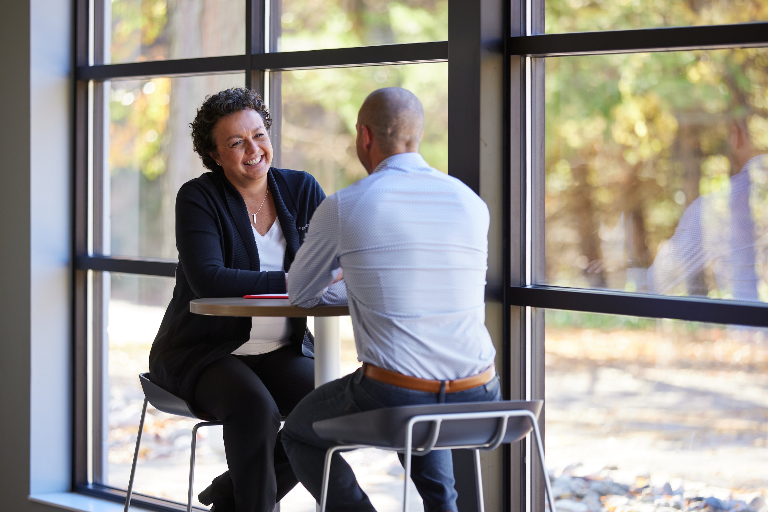 Two colleagues sitting at a table, enjoying a conversation