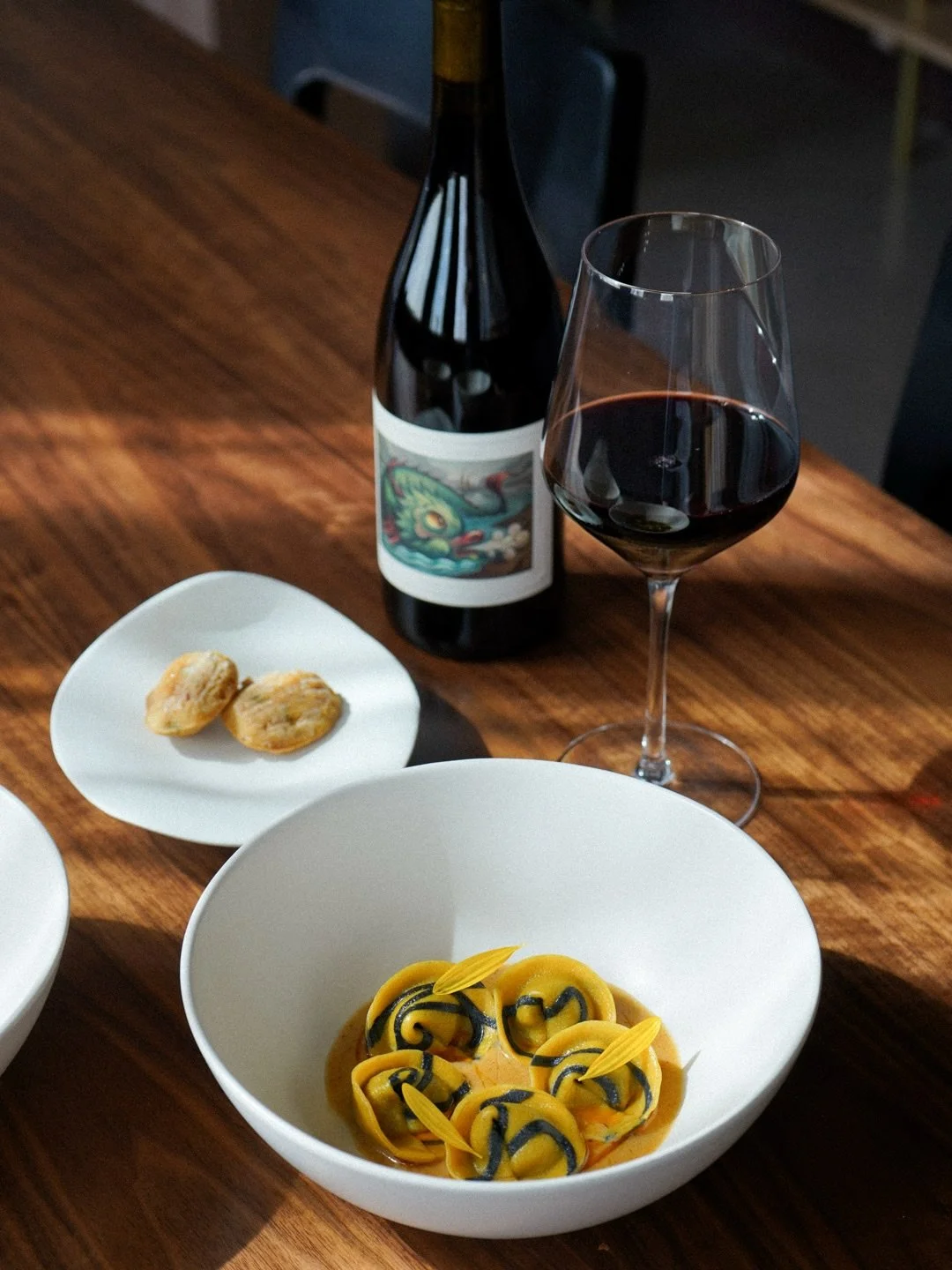 black &amp; yellow: @hifimyco mushroom cappelletti in a spiced local corn chowder, finished with sunflower petals from @hausbar_urban_farm and served with cornbread madeleines made with Texas cornmeal on the side 🌽 each little piece of pasta hand-sh