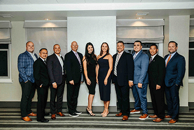 group of well dressed people standing and posing for picture