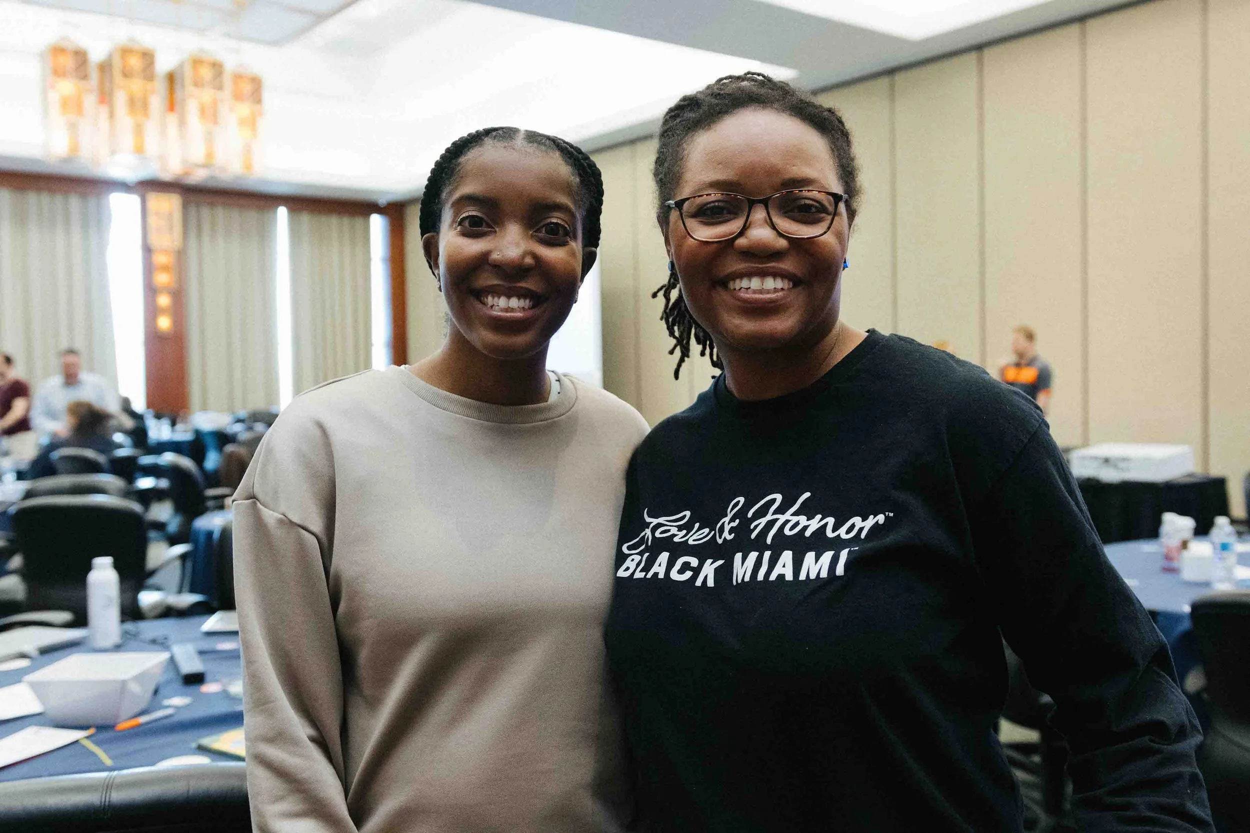 Two women posing for picture at a work event