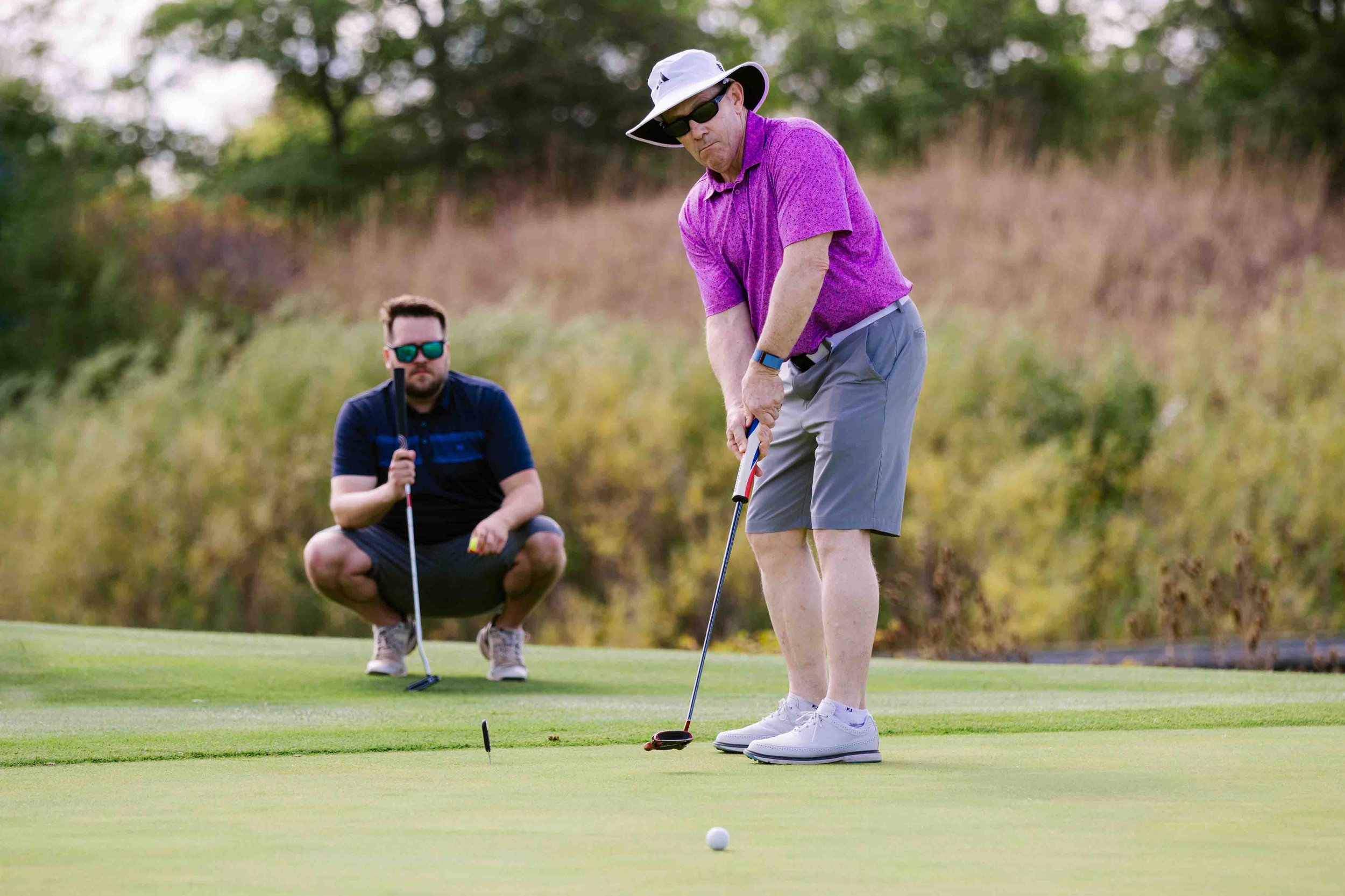Two men at golf event playing golf