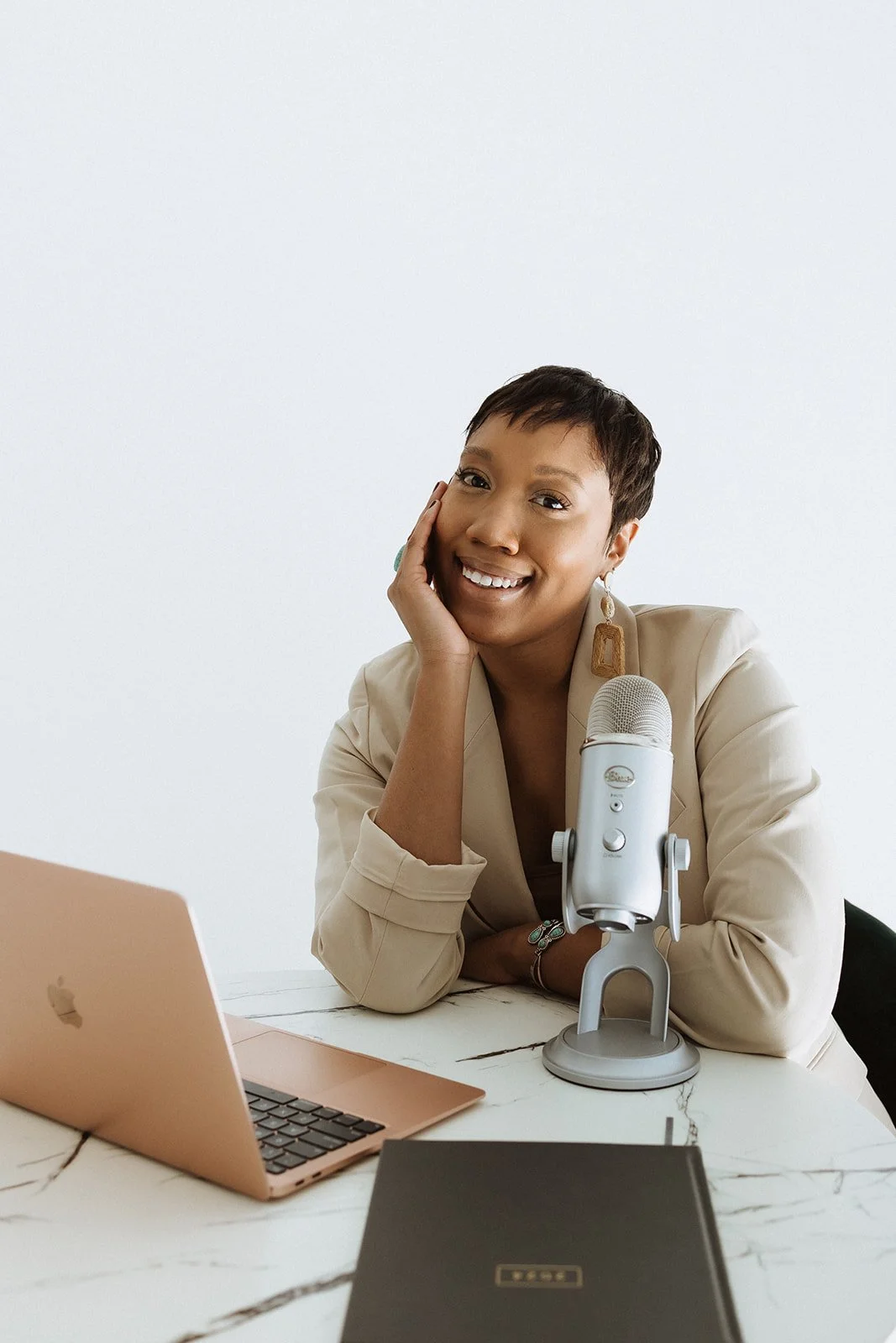 Woman smiling next to her podcast microphone