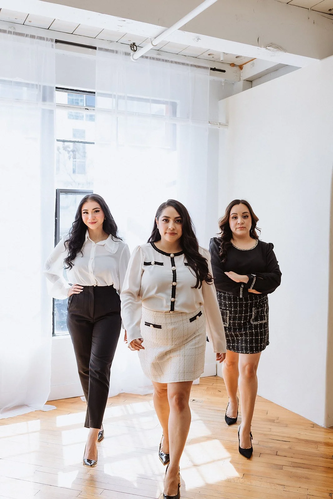 Three woman walking towards the camera in a studio