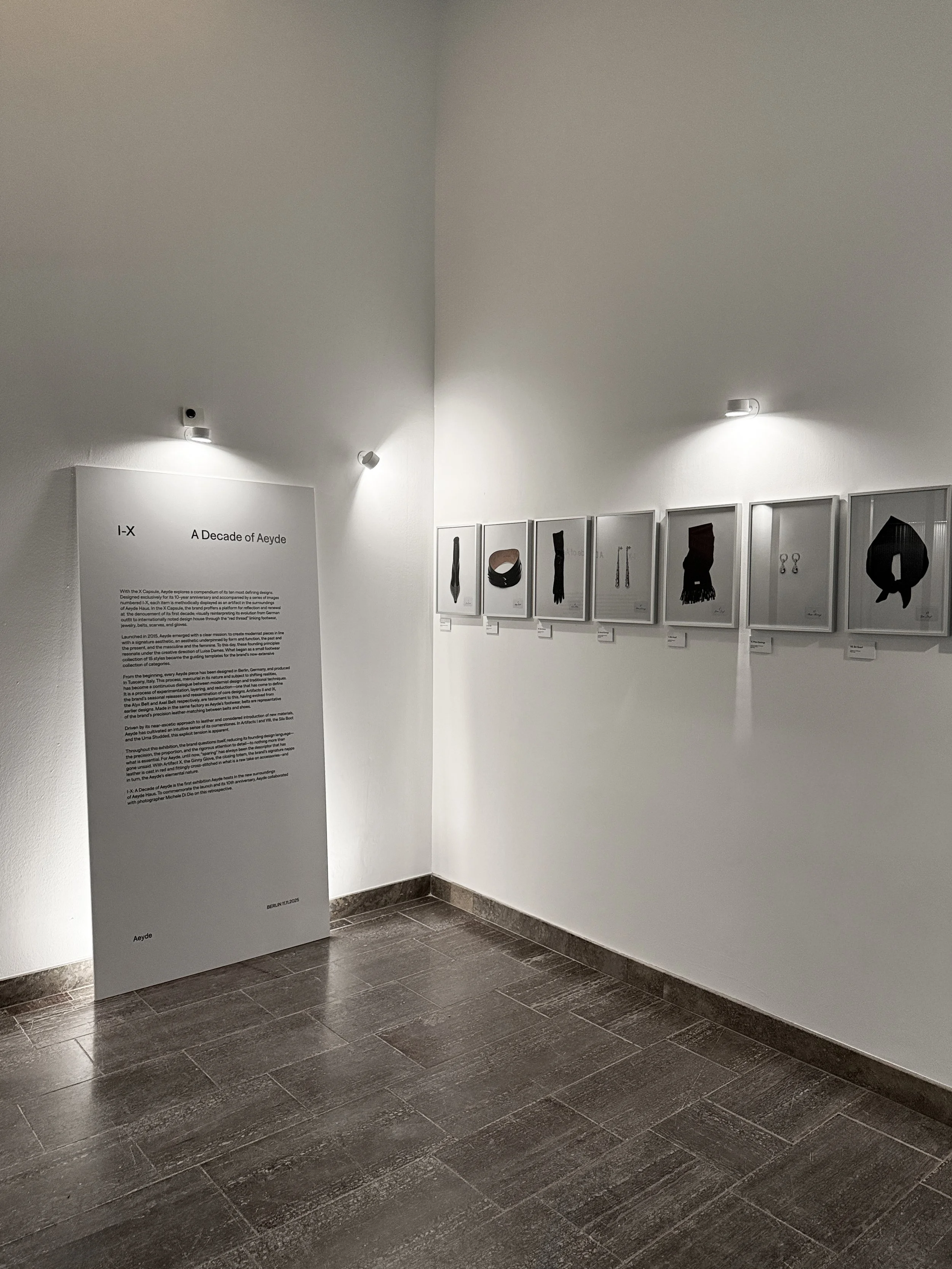 Beginning of Aeyde Haus exhibition with exhibit texts on a large board, surrounded by mounted images