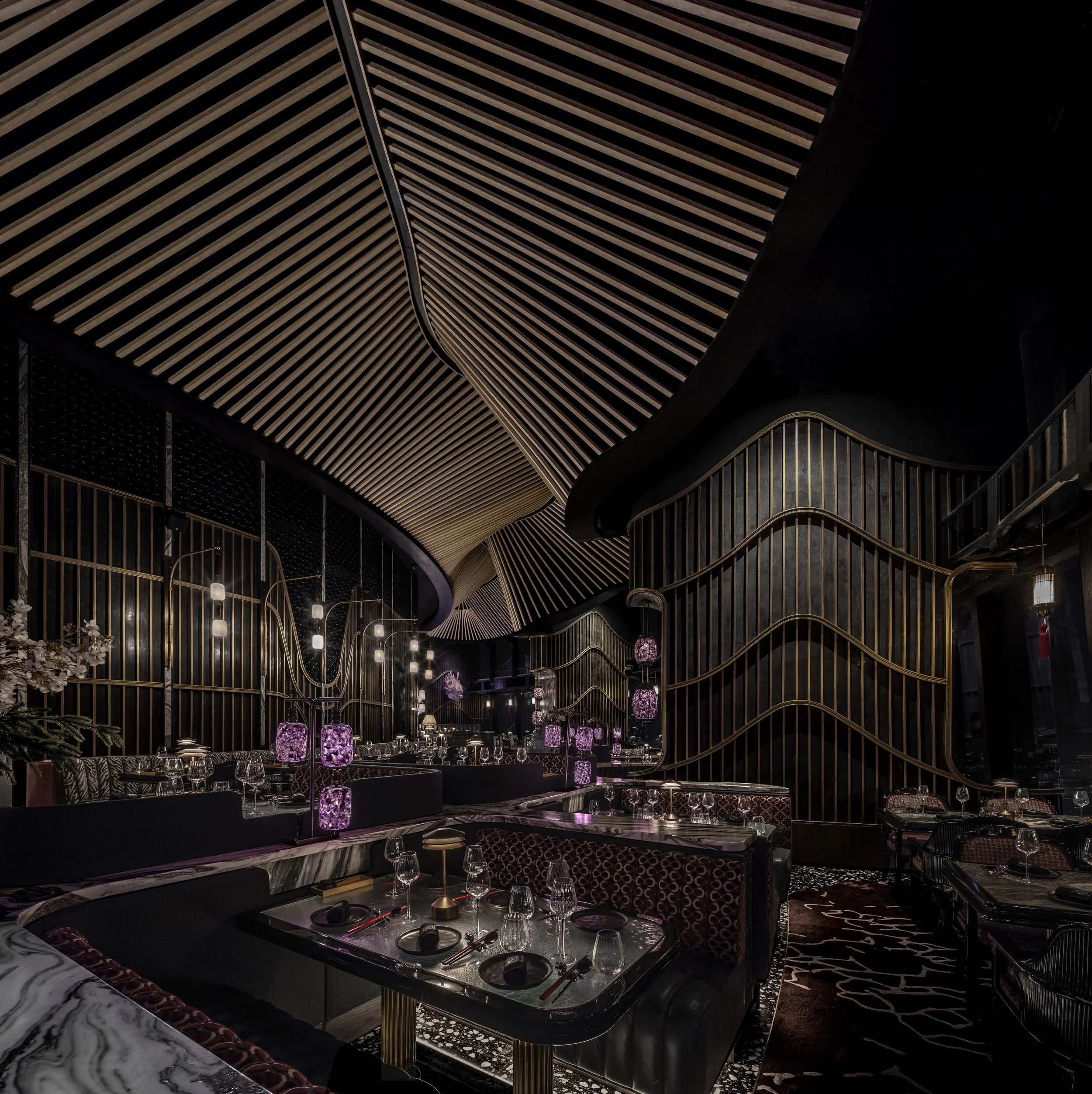 Photograph of the TATTU Dubai restaurant, with an undulating ceiling sweeping through the space.