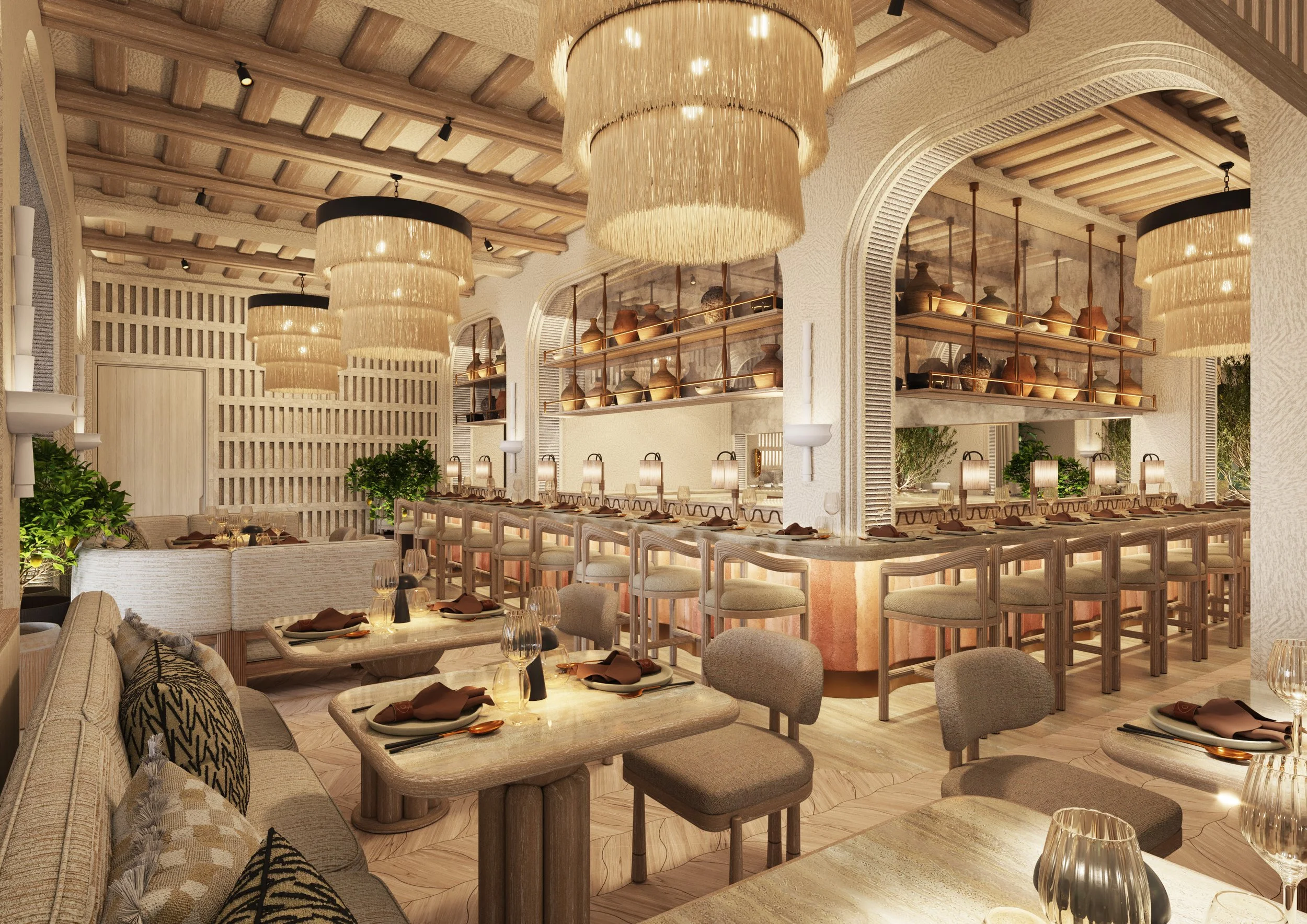 A view of the open kitchen with arched openings framing views through and into the restaurant. The counterfront is a natural rammed earth finish. Oversized natural fiber lampshades hang along the ceiling.