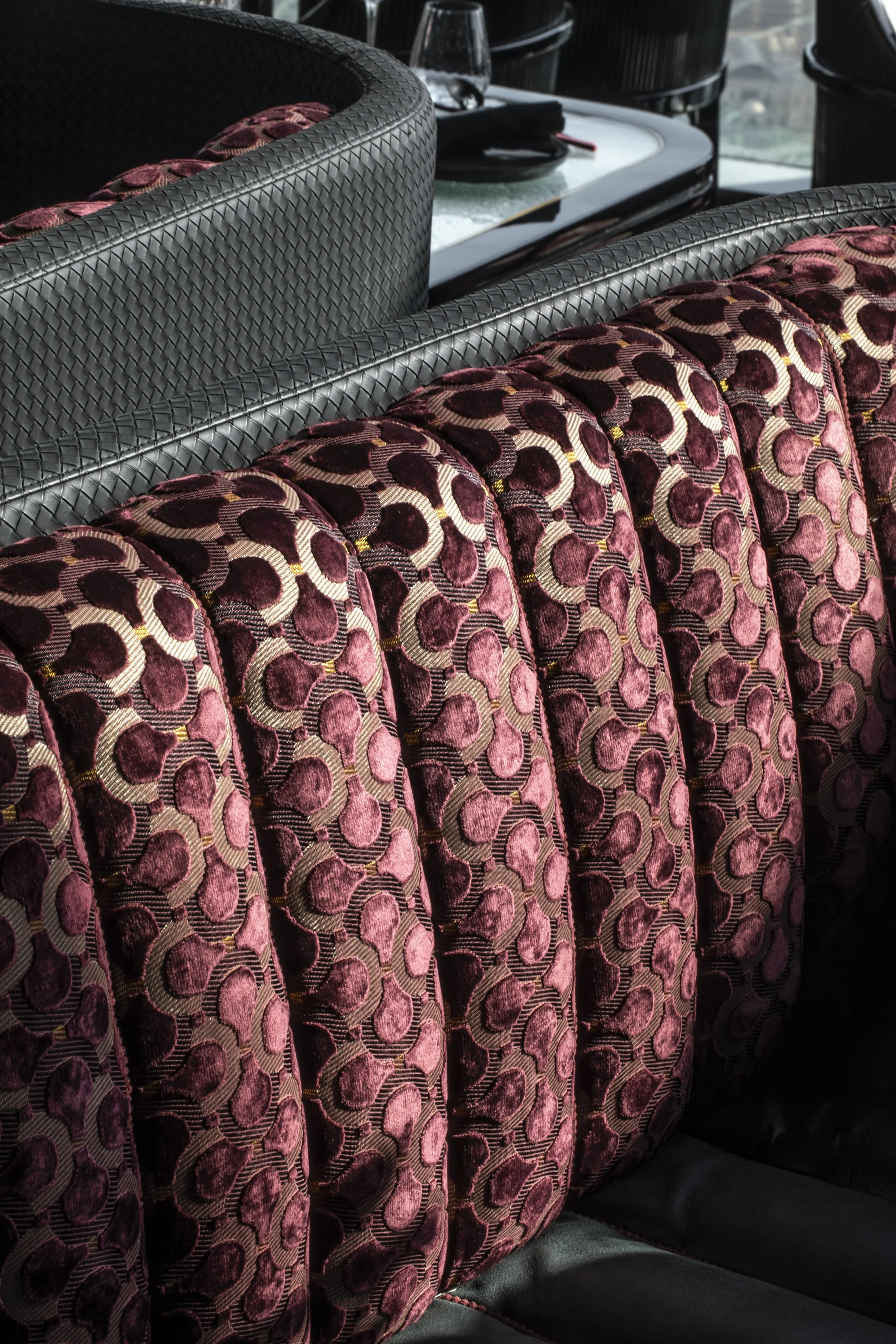 Close up shot of a banquette with purple curved interlocking pattern by Dedar.