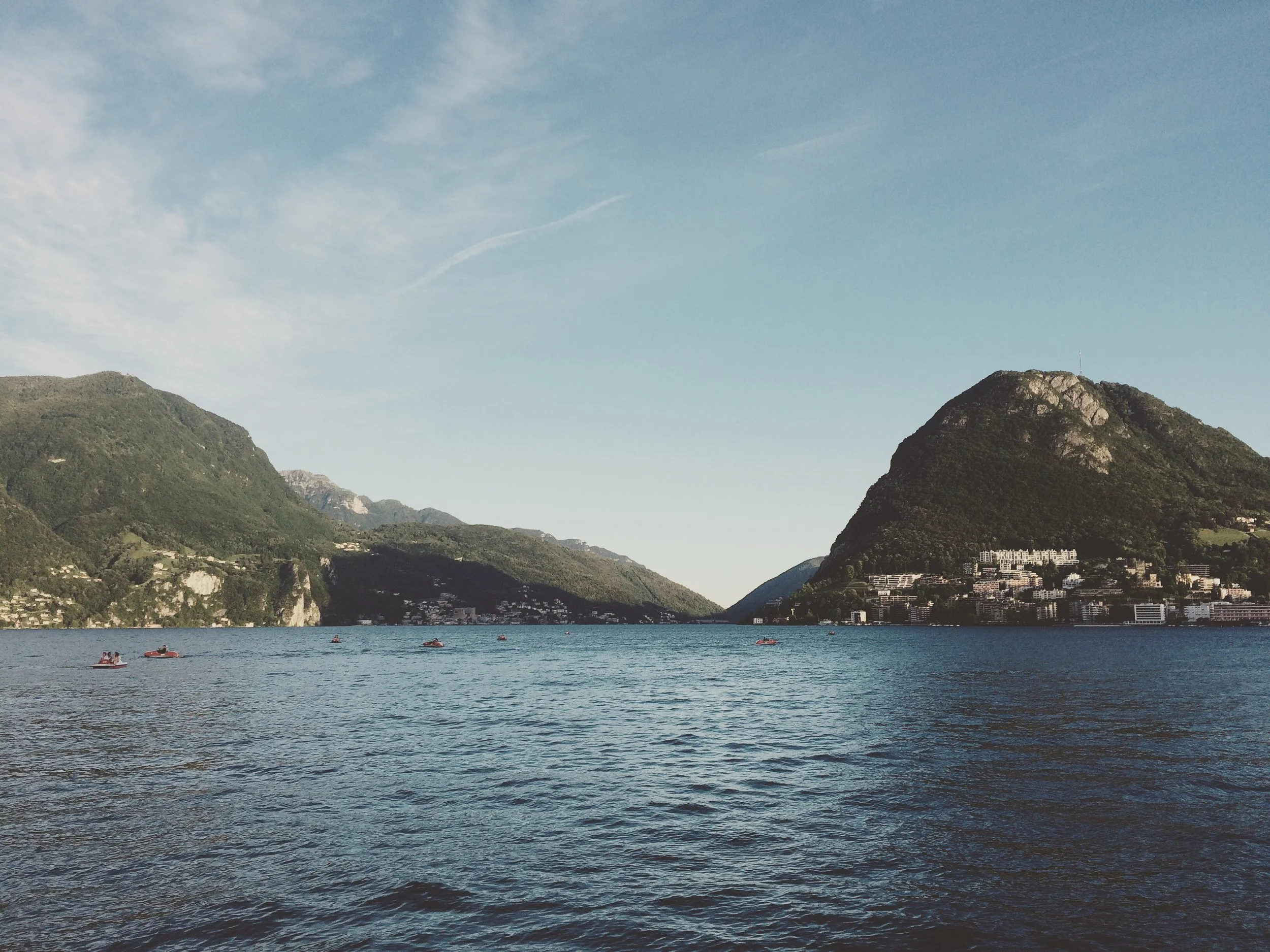 An image of Lago di Lugano with Monte Bre in the background. Blue skies and blue water.
