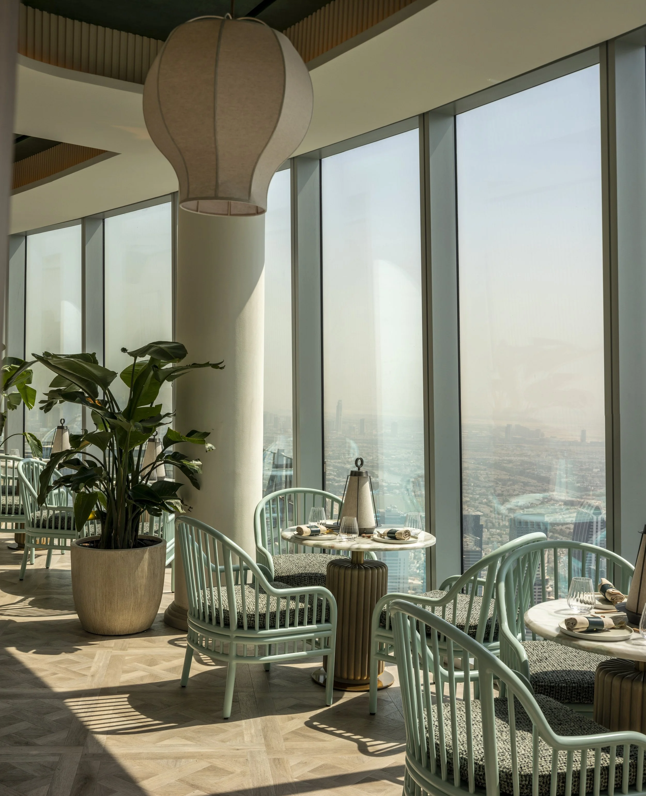 Dining at the sushi bar. Ribbed timber base tables and painted bamboo armchairs.