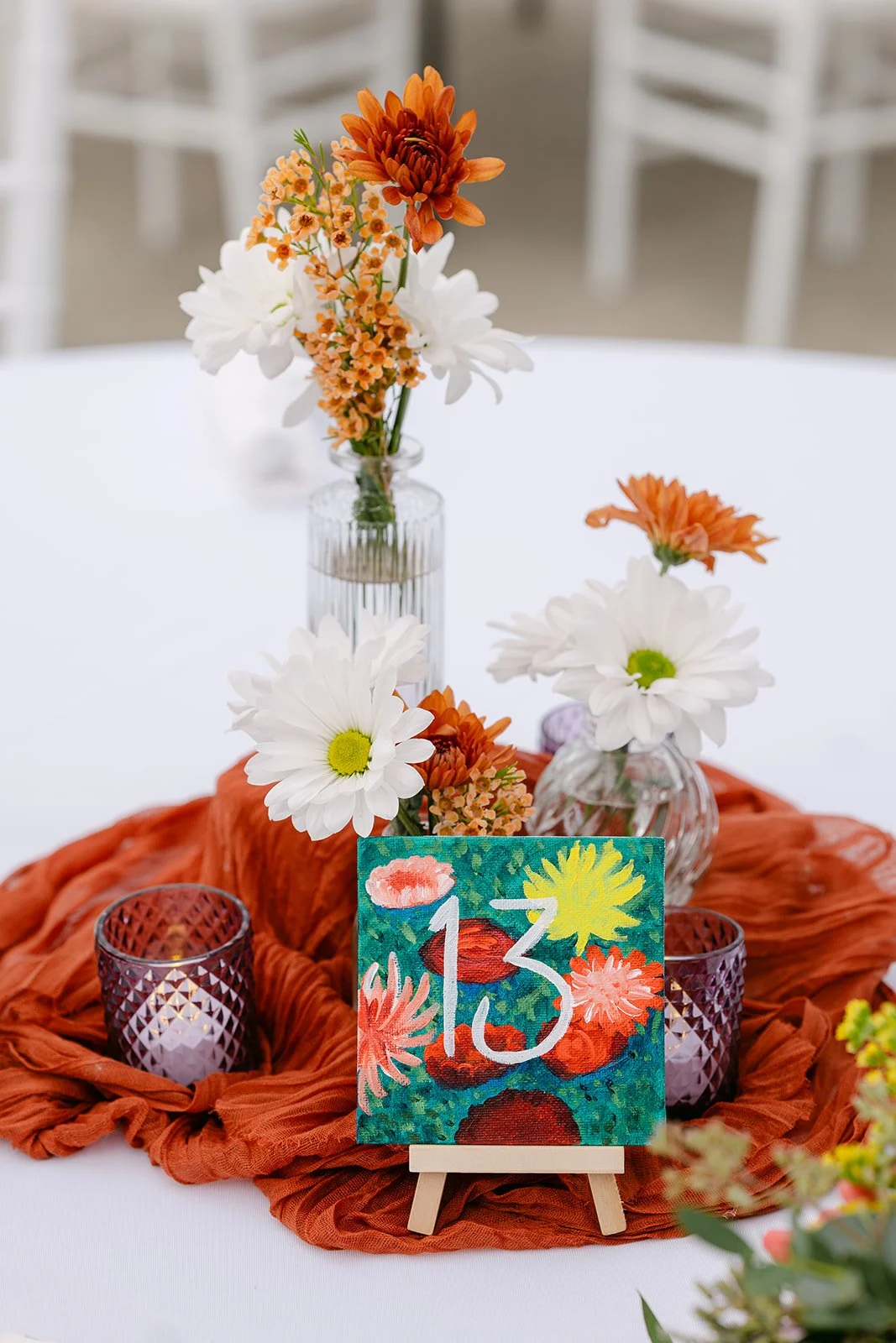 Colorful hand-painted table numbers for an Abele Greenhouse wedding reception in Saginaw, Michigan.