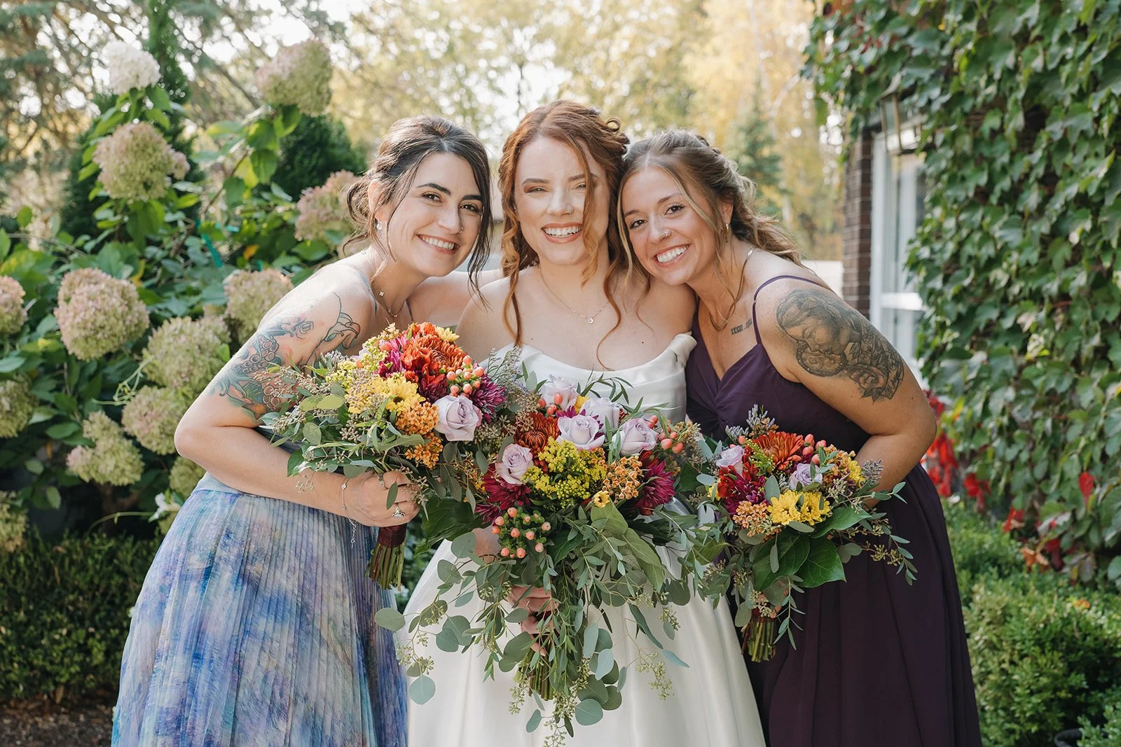 Close up shot of the bride smiling with two bridesmaids outside of Brownstone Haus in Frankenmuth, Michigan.
