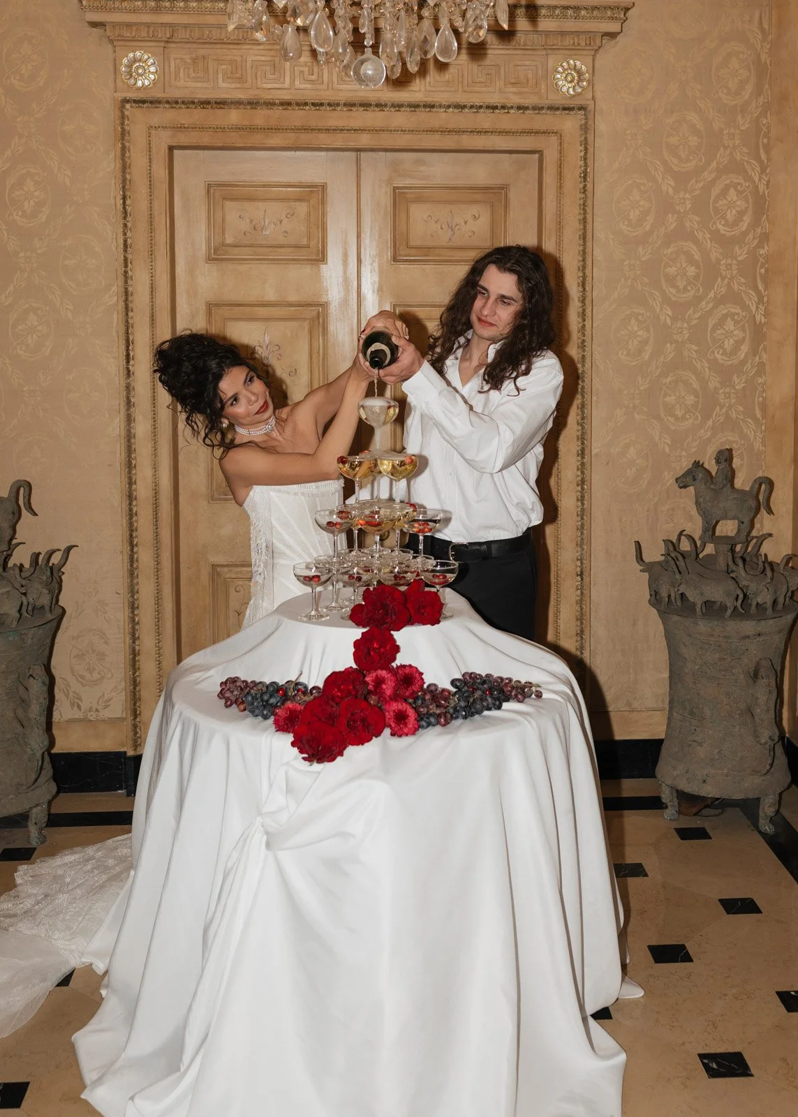 A bride and groom pouring champagne over their champagne tower at Clairwood Estate