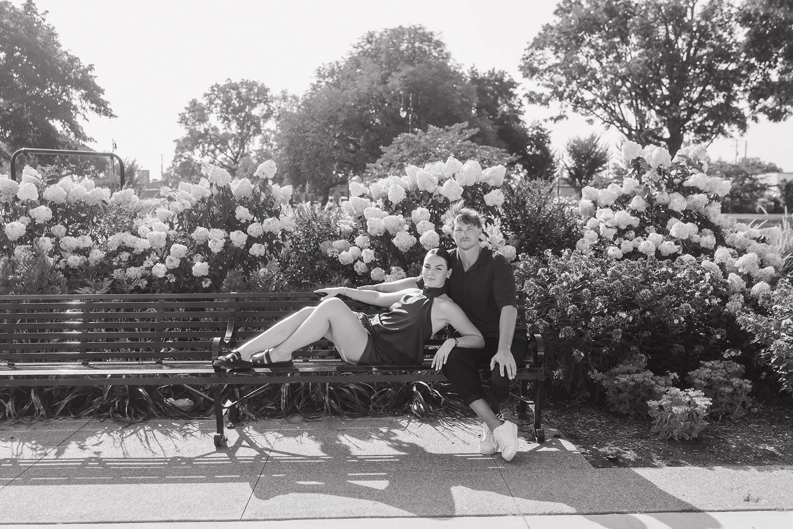 Black and white photo of a couple posing on the benches outside of Michigan Central Station.