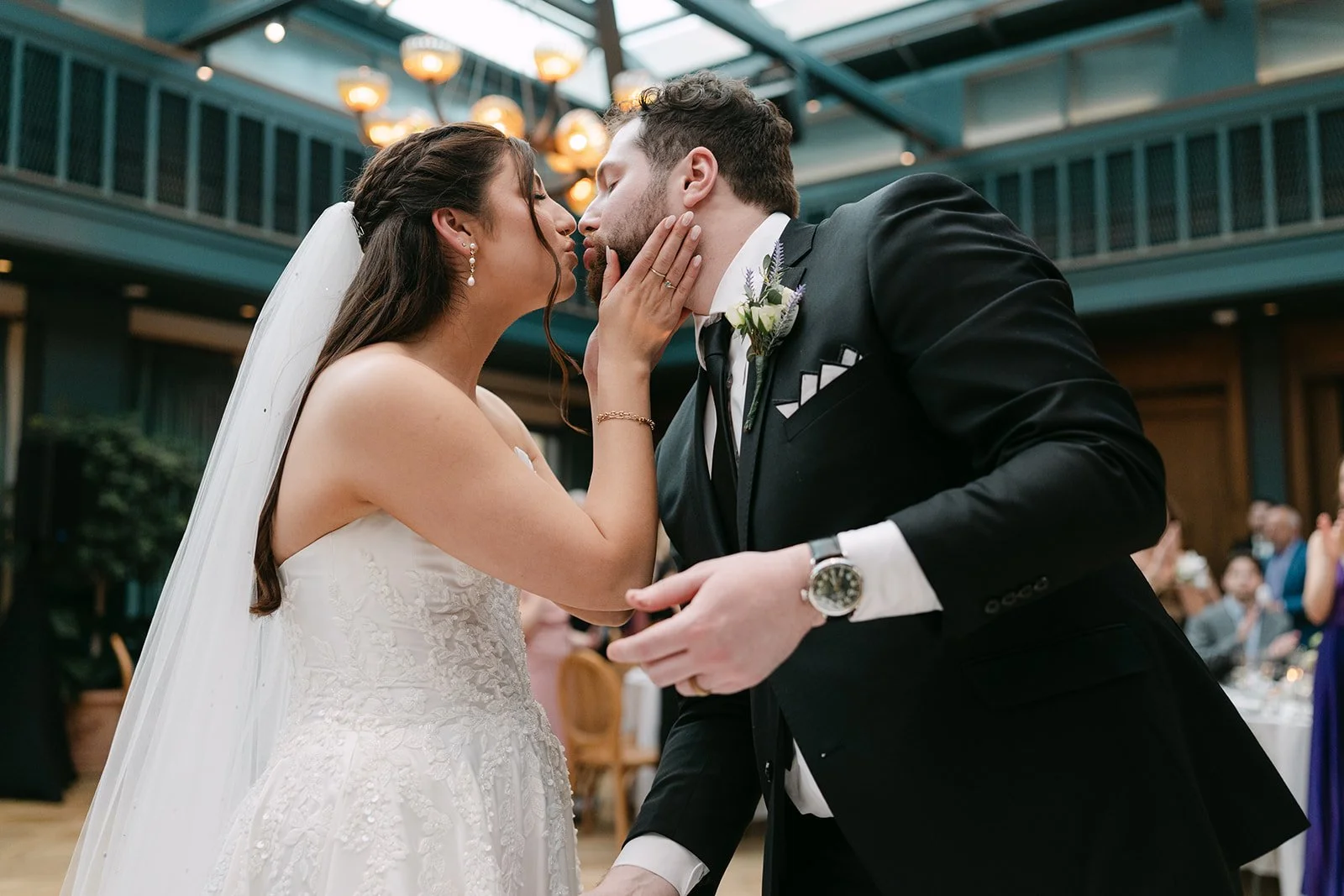 Bride and groom kissing after cake cutting in The Conservatory at Book Tower in Detroit.