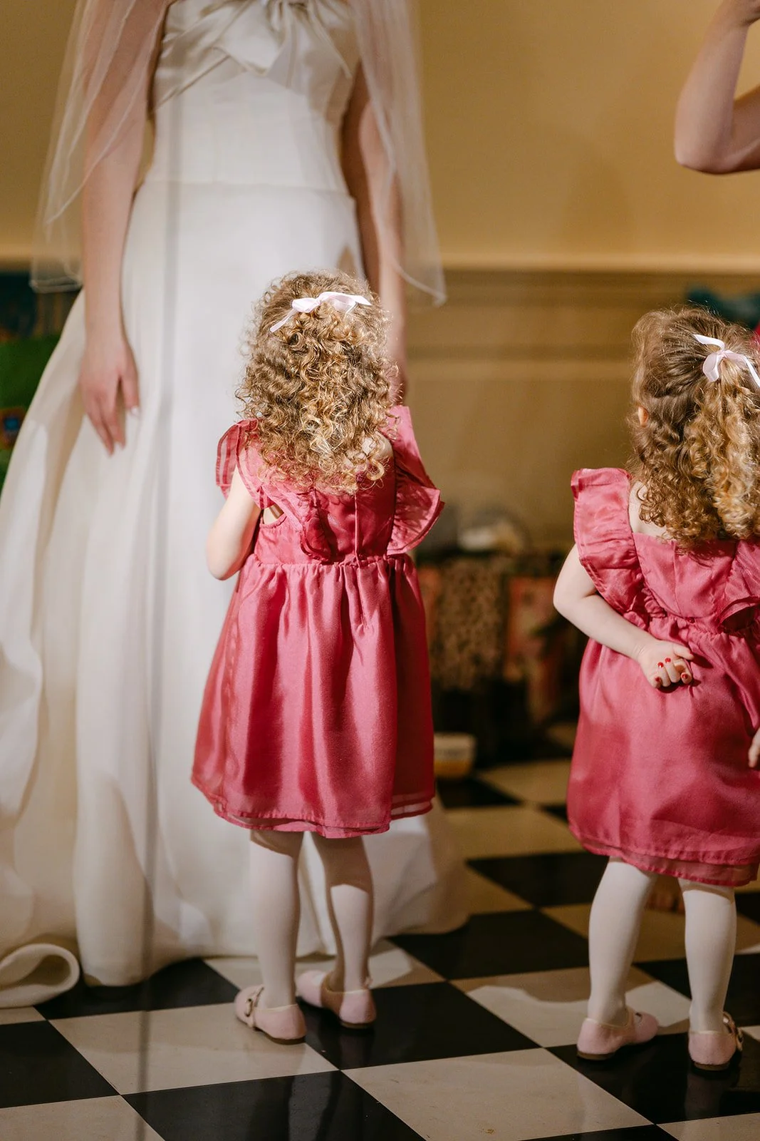 Flower girls admiring the bride in her wedding dress.