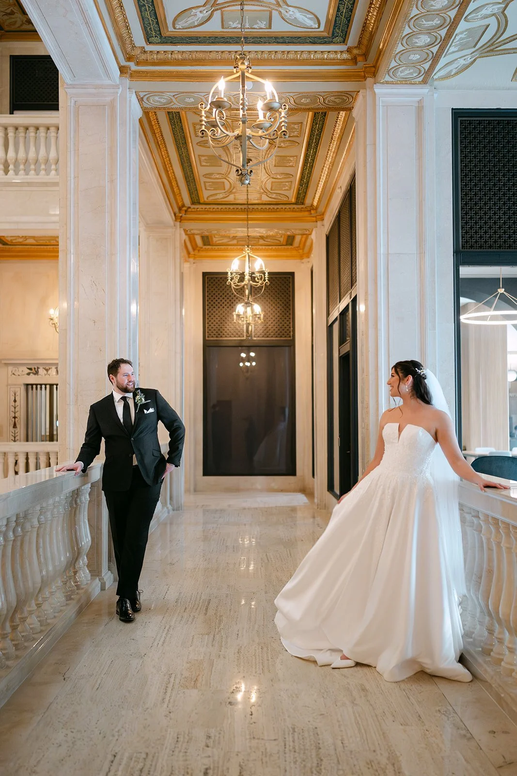 Bride and groom posing for photos on the second floor of Book Tower in Detroit, MI.